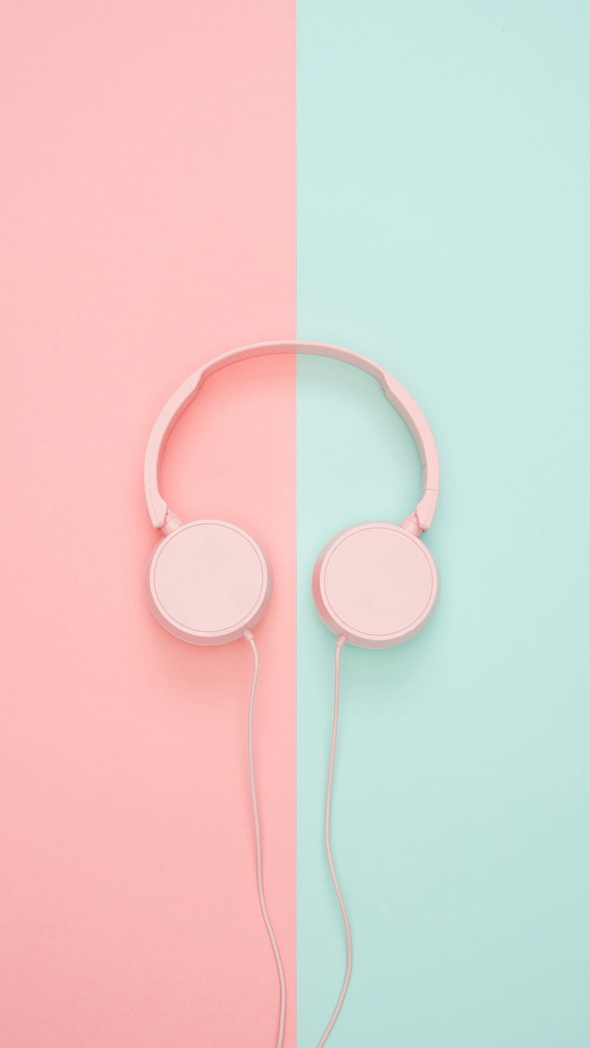 A pair of pink headphones on a pink and blue background - Pastel minimalist