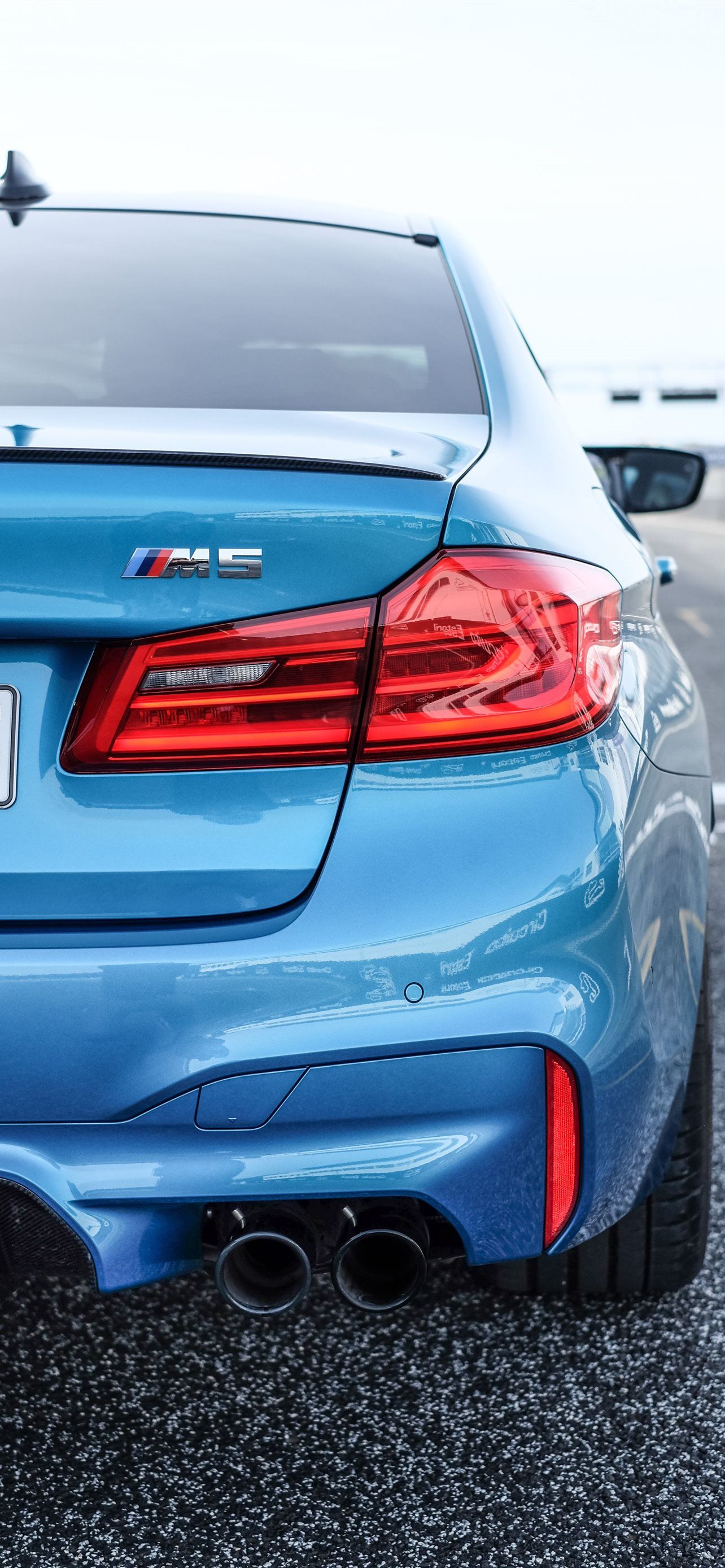 A blue BMW M5 with the rear lights on. - BMW