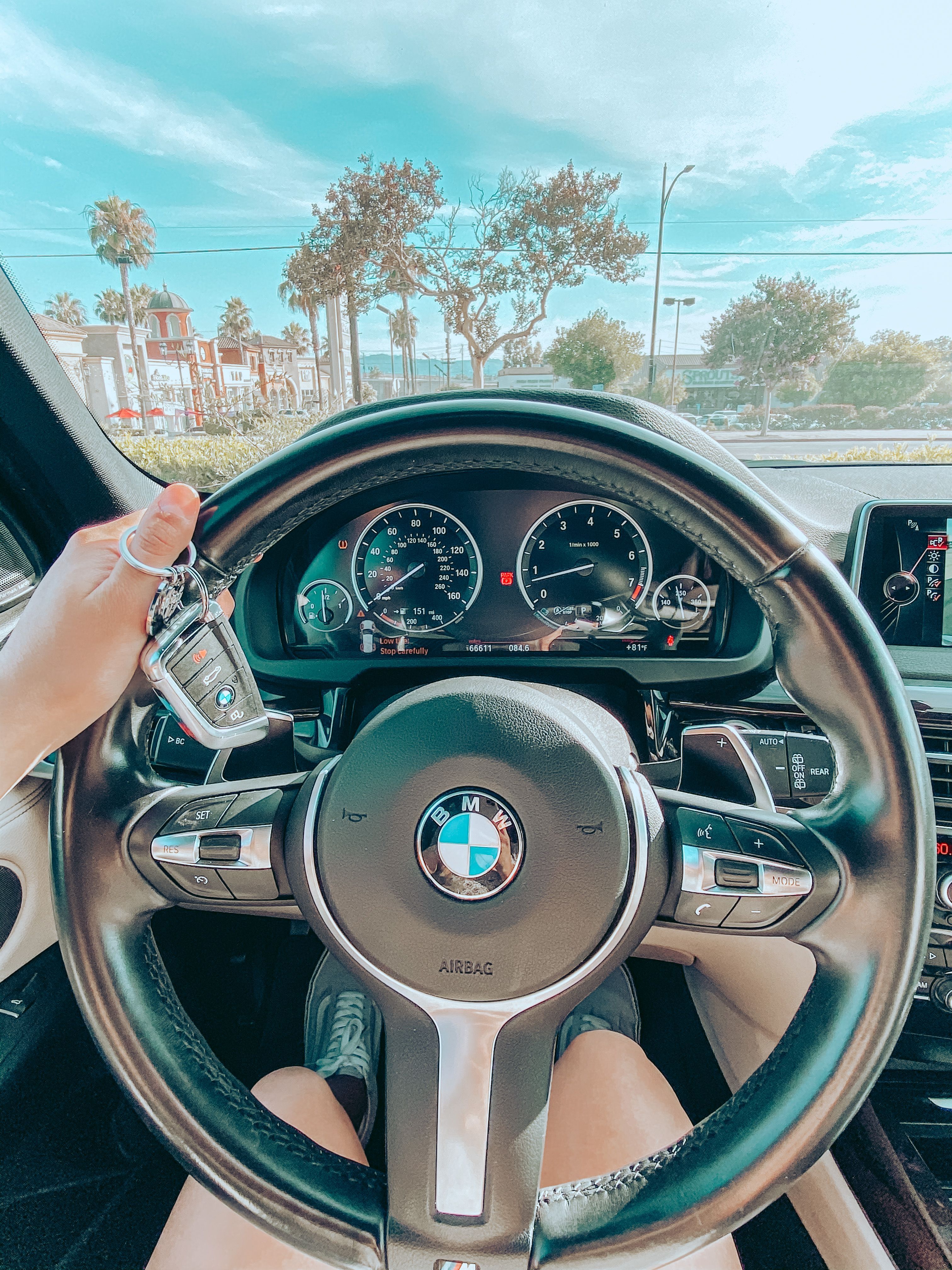 A woman's hand on the steering wheel of a BMW. - BMW