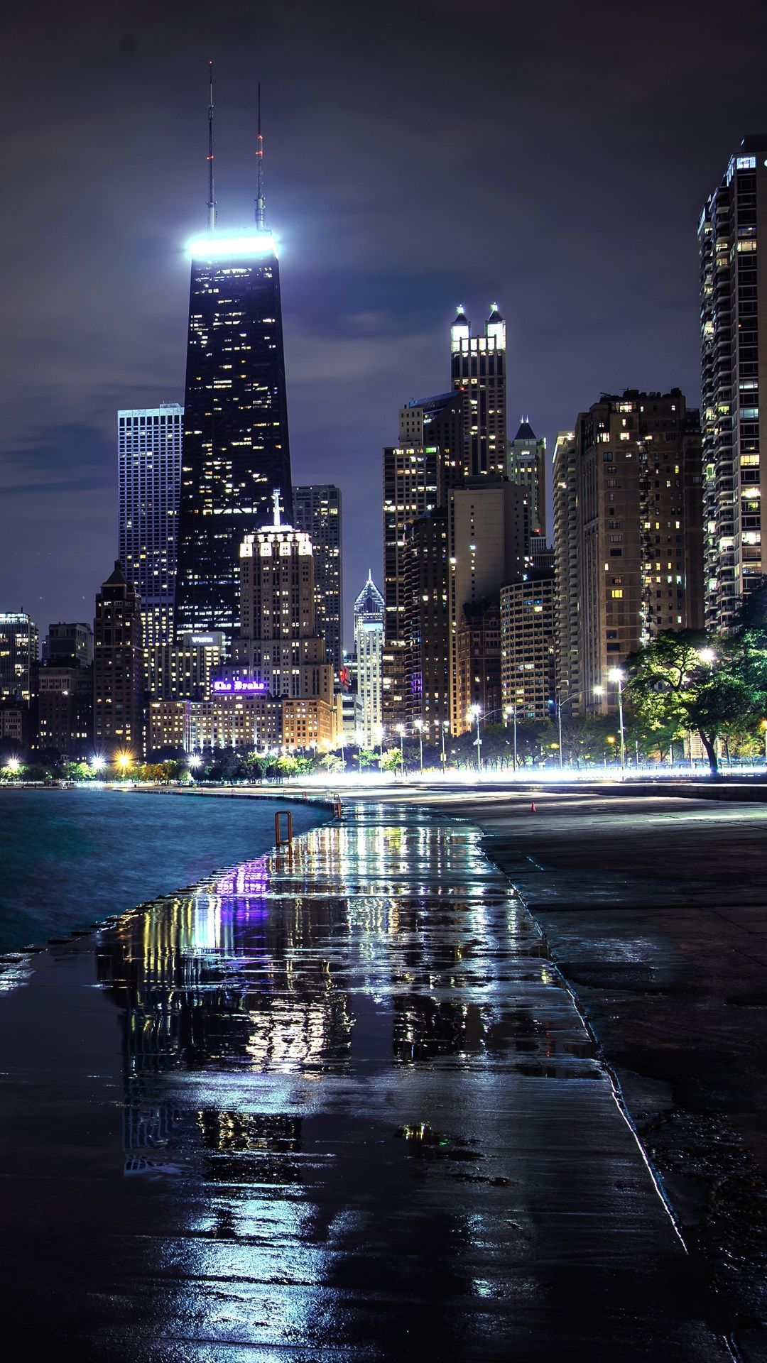 IPhone wallpaper of Chicago skyline at night with lights reflecting on the wet pavement - Chicago