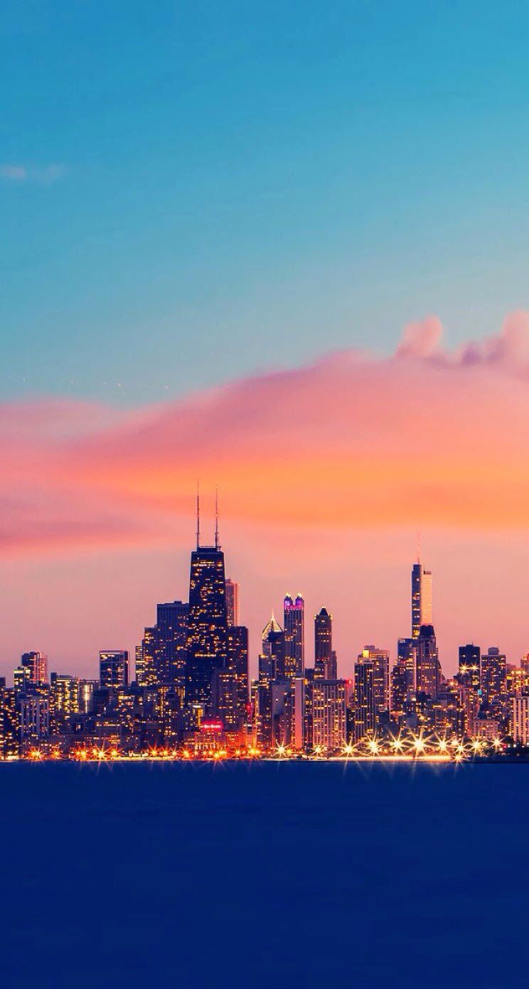 A city skyline with a blue and orange sky - Chicago