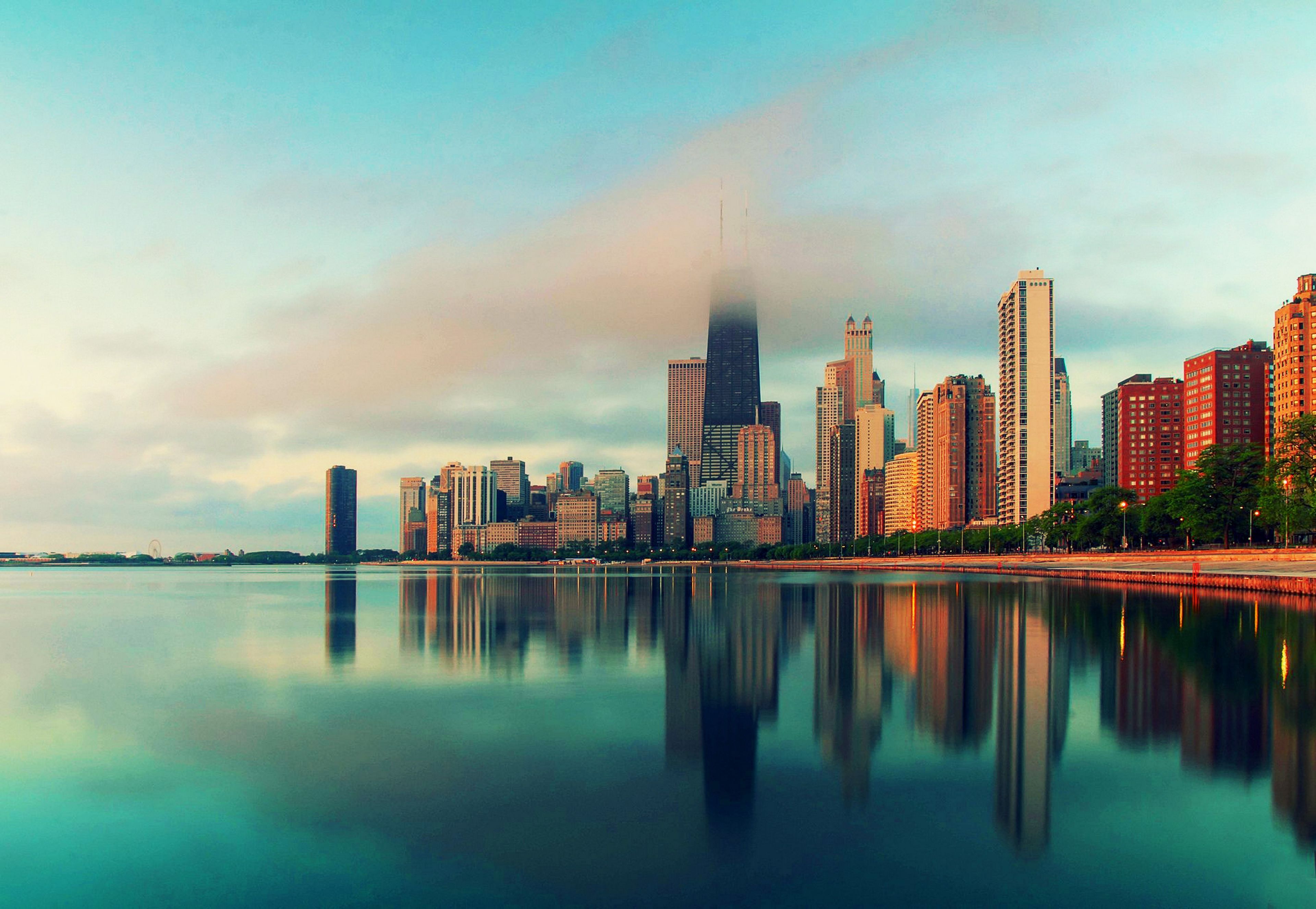 A beautiful cityscape of Chicago with the reflection of the buildings in the water. - Chicago