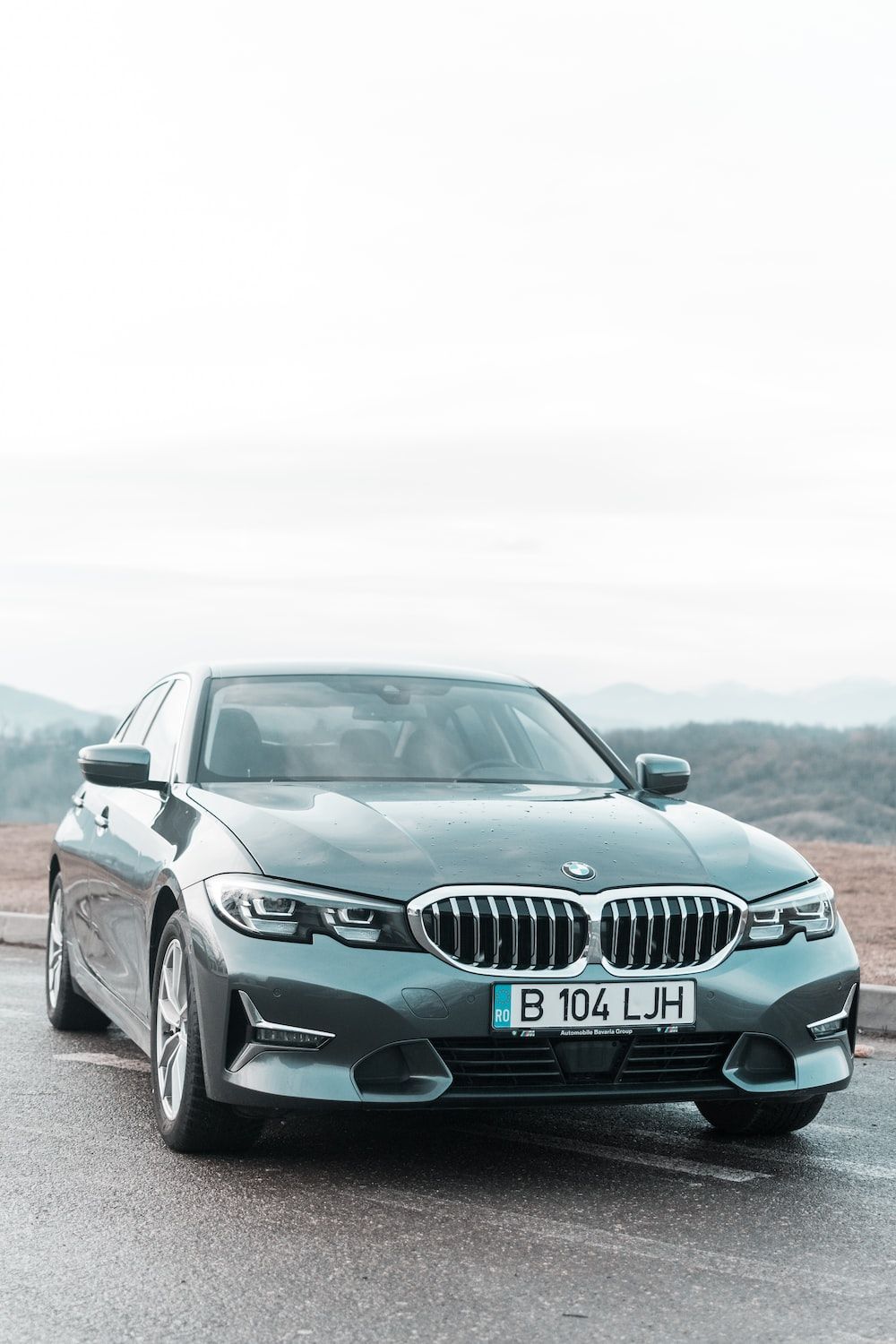 A grey 2020 BMW 320i Sedan parked on the side of a road. - BMW