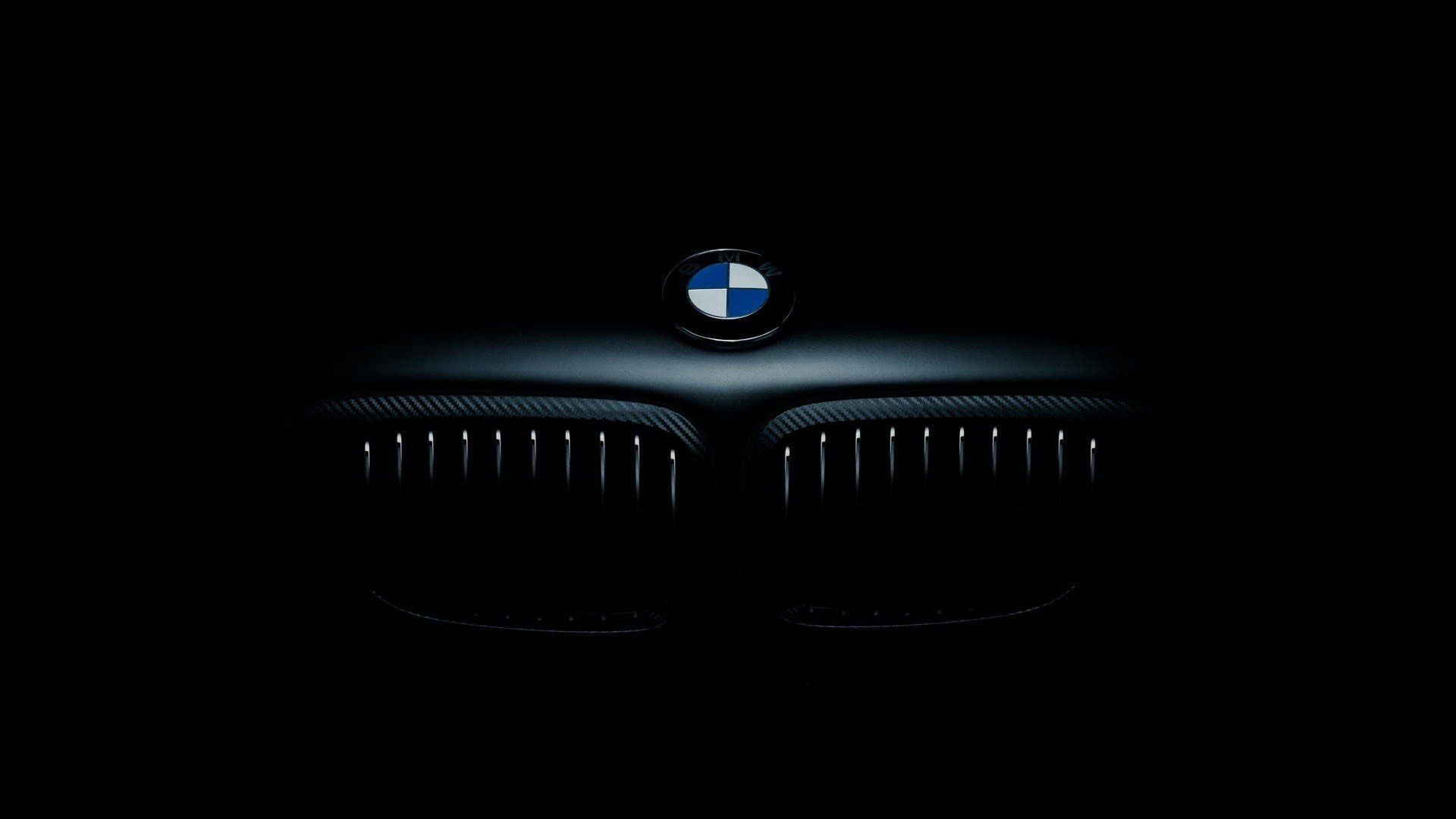 A black background with the front grill of a BMW in the center. - BMW