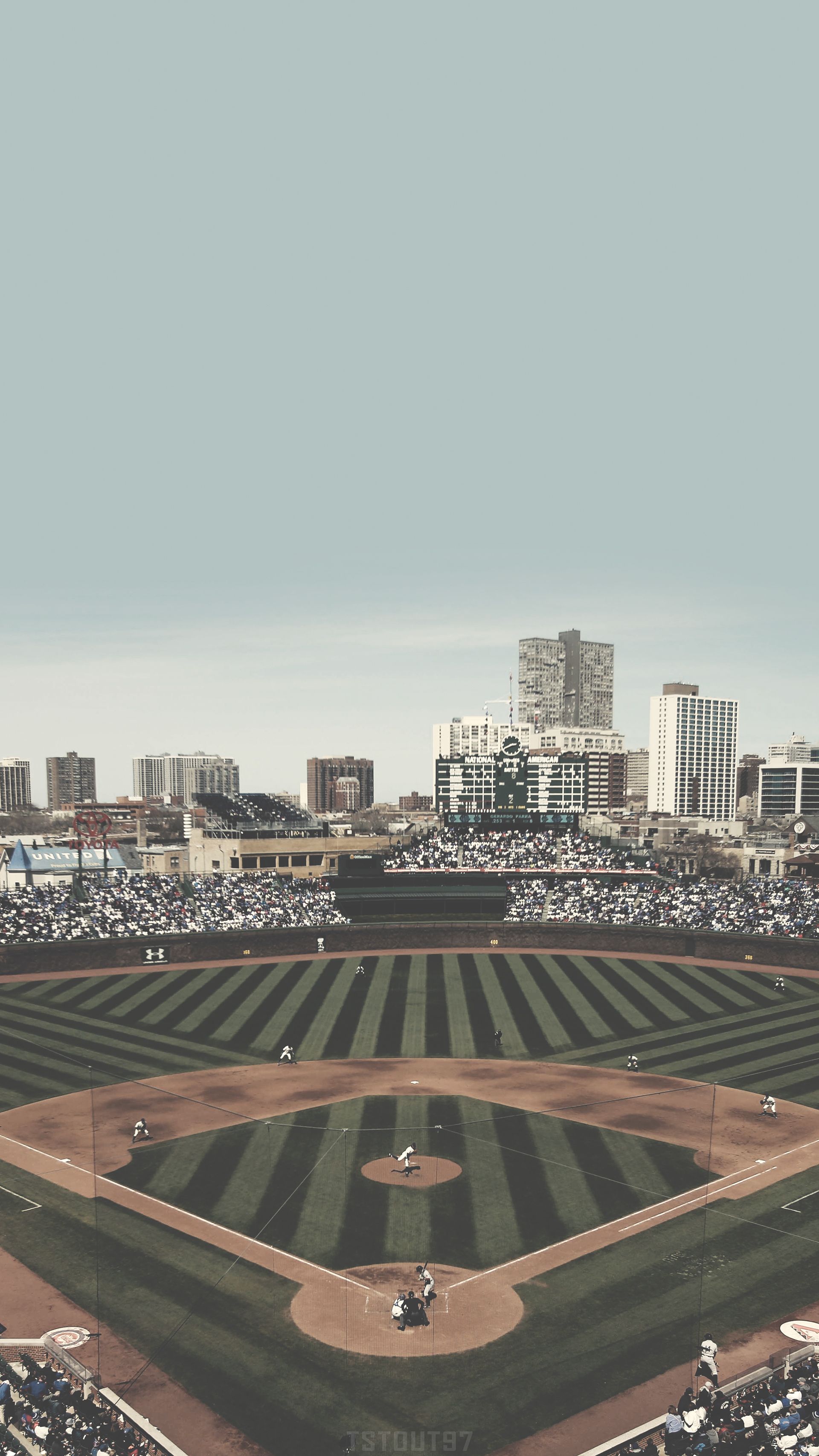 A baseball game in a large stadium with a city skyline in the background - Chicago