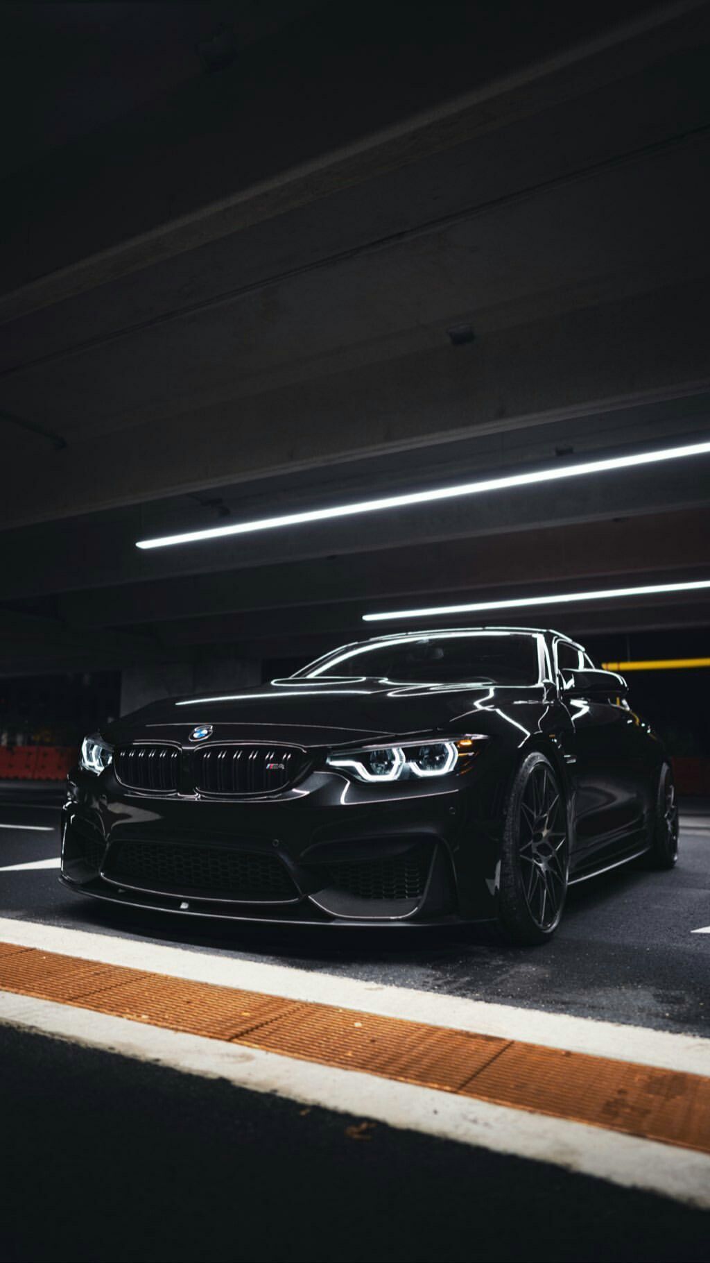 A black BMW M2 parked in a dark parking garage. - BMW