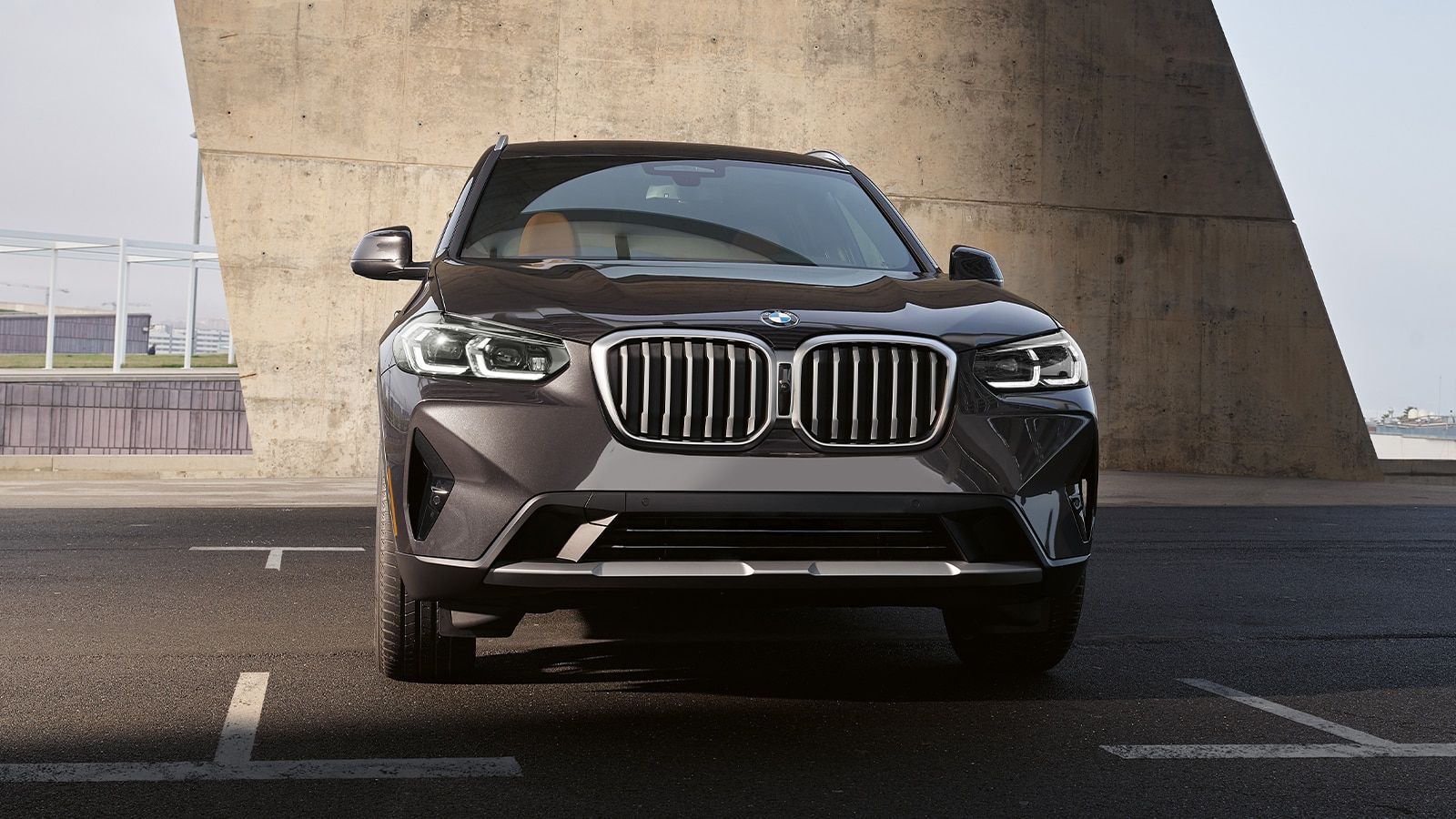 The front end of a 2021 BMW X3 parked in a parking lot - BMW