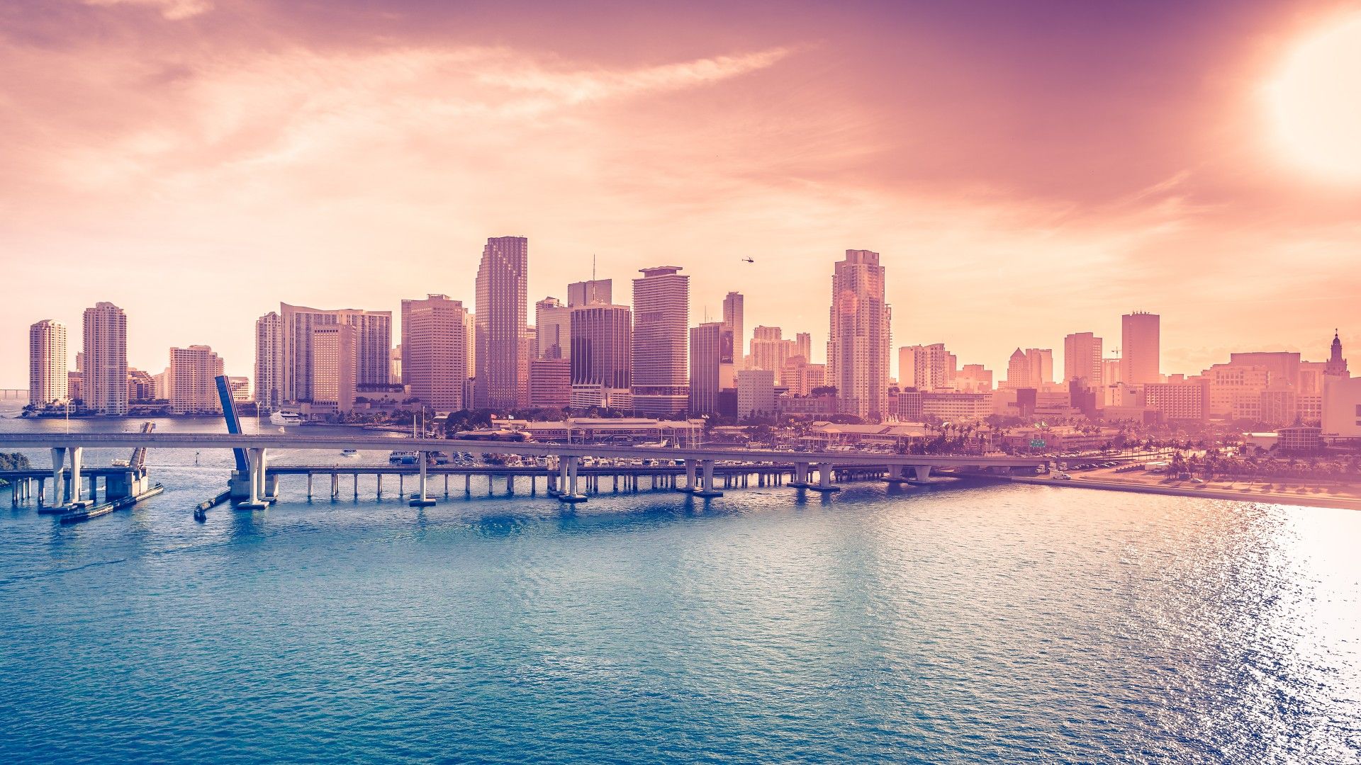 A city skyline with tall buildings on the shore of a body of water - Miami