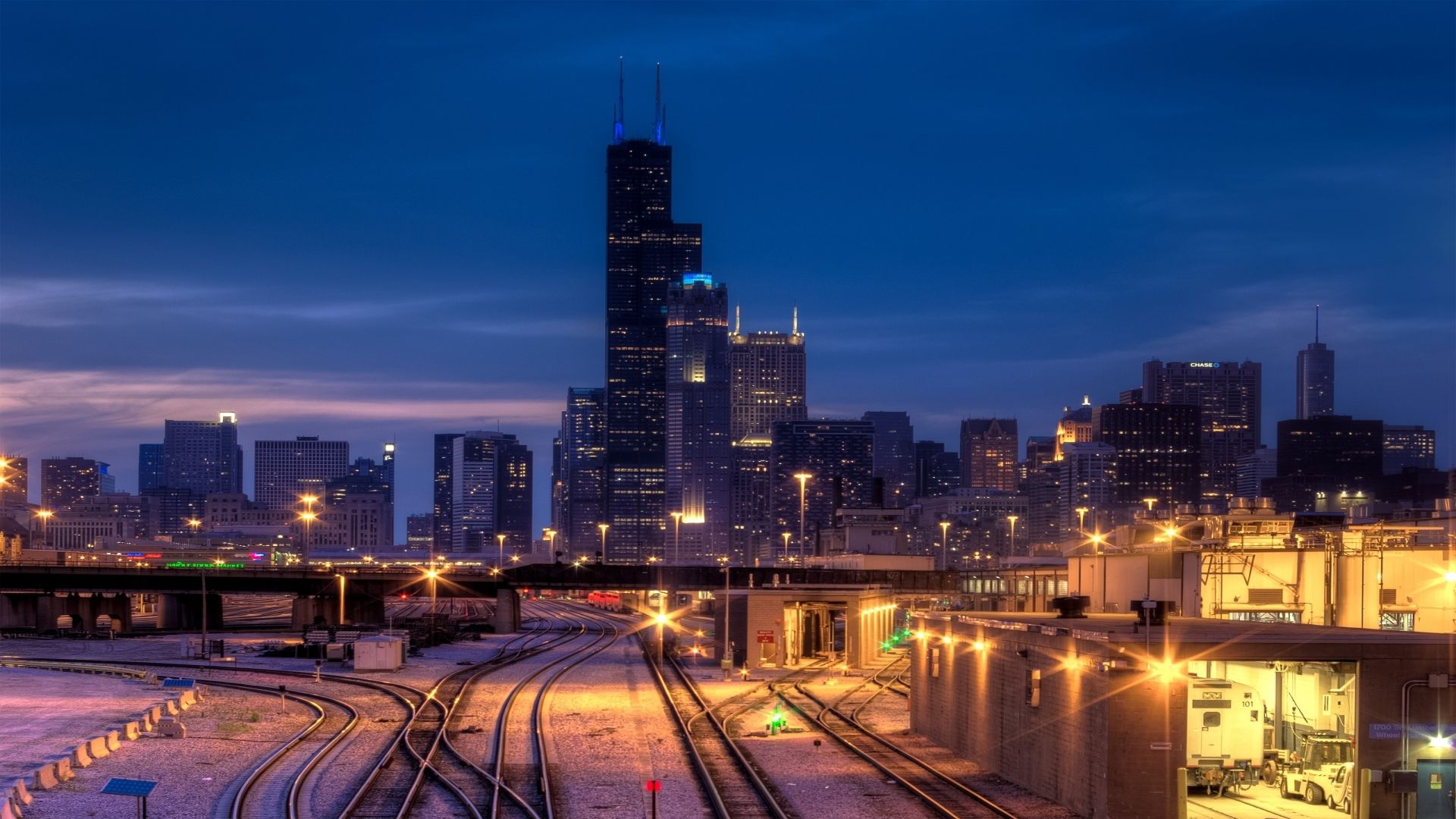 A train station with tracks and buildings in the background - Chicago