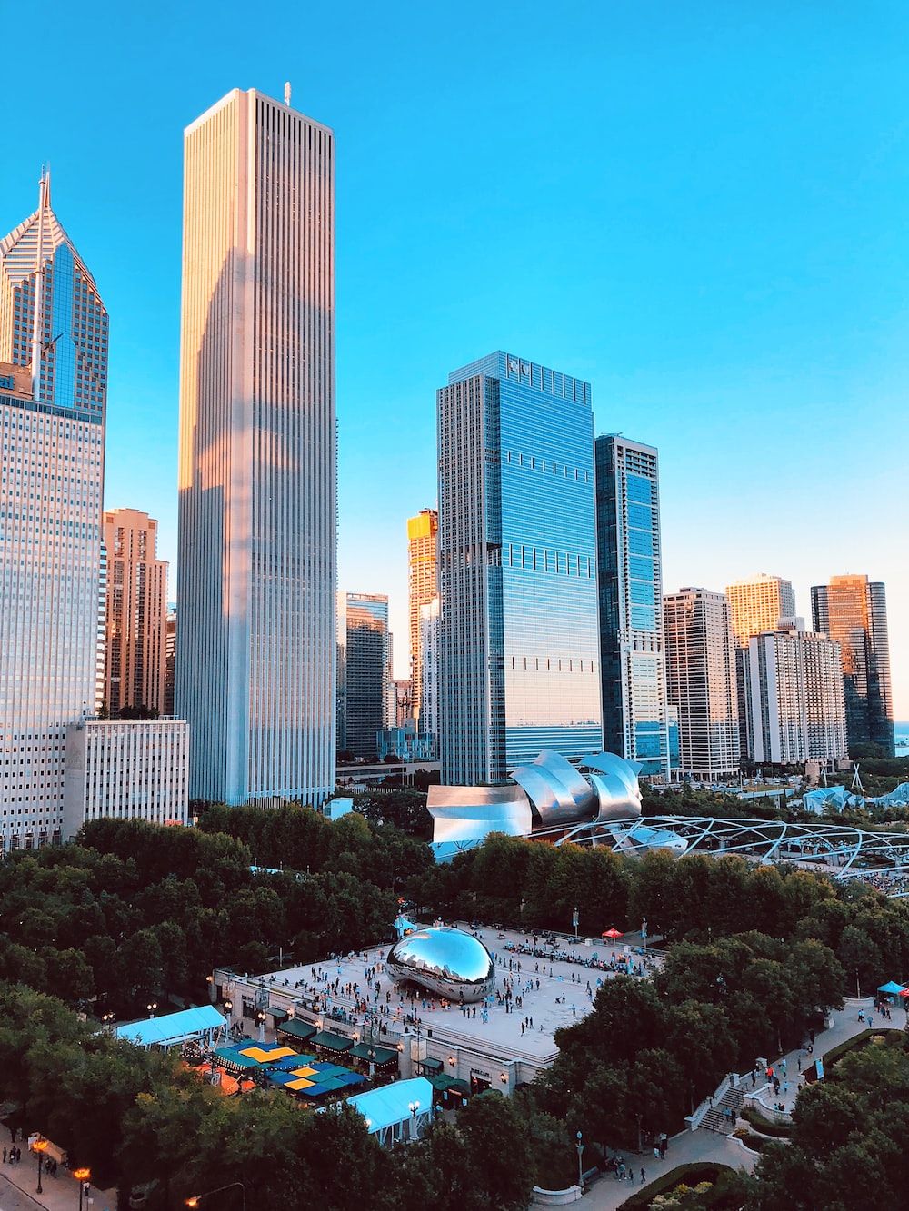 The Chicago skyline at sunset, with the famous Cloud Gate sculpture in the foreground. - Chicago