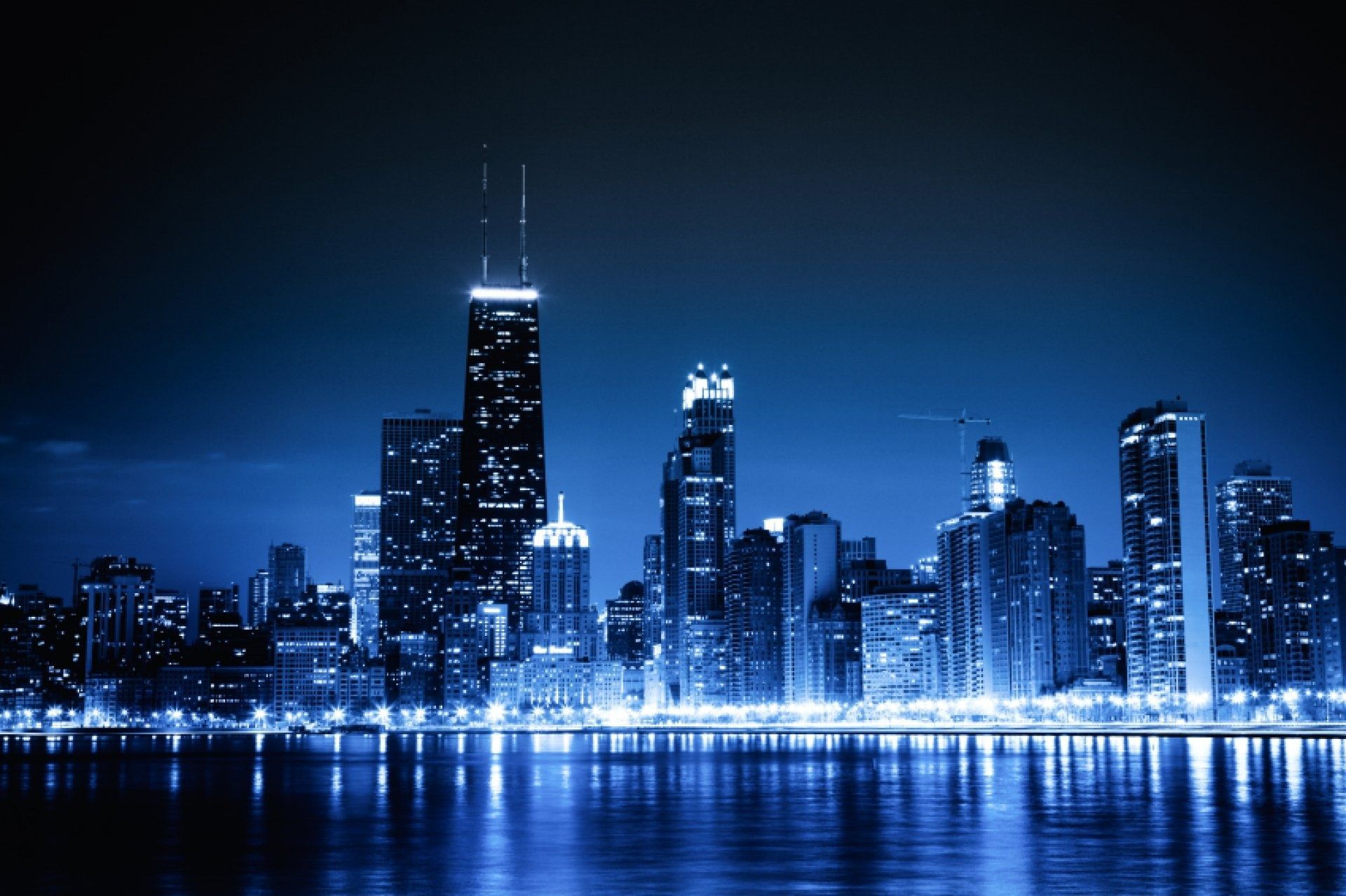 A city skyline at night with the water in front of it - Chicago