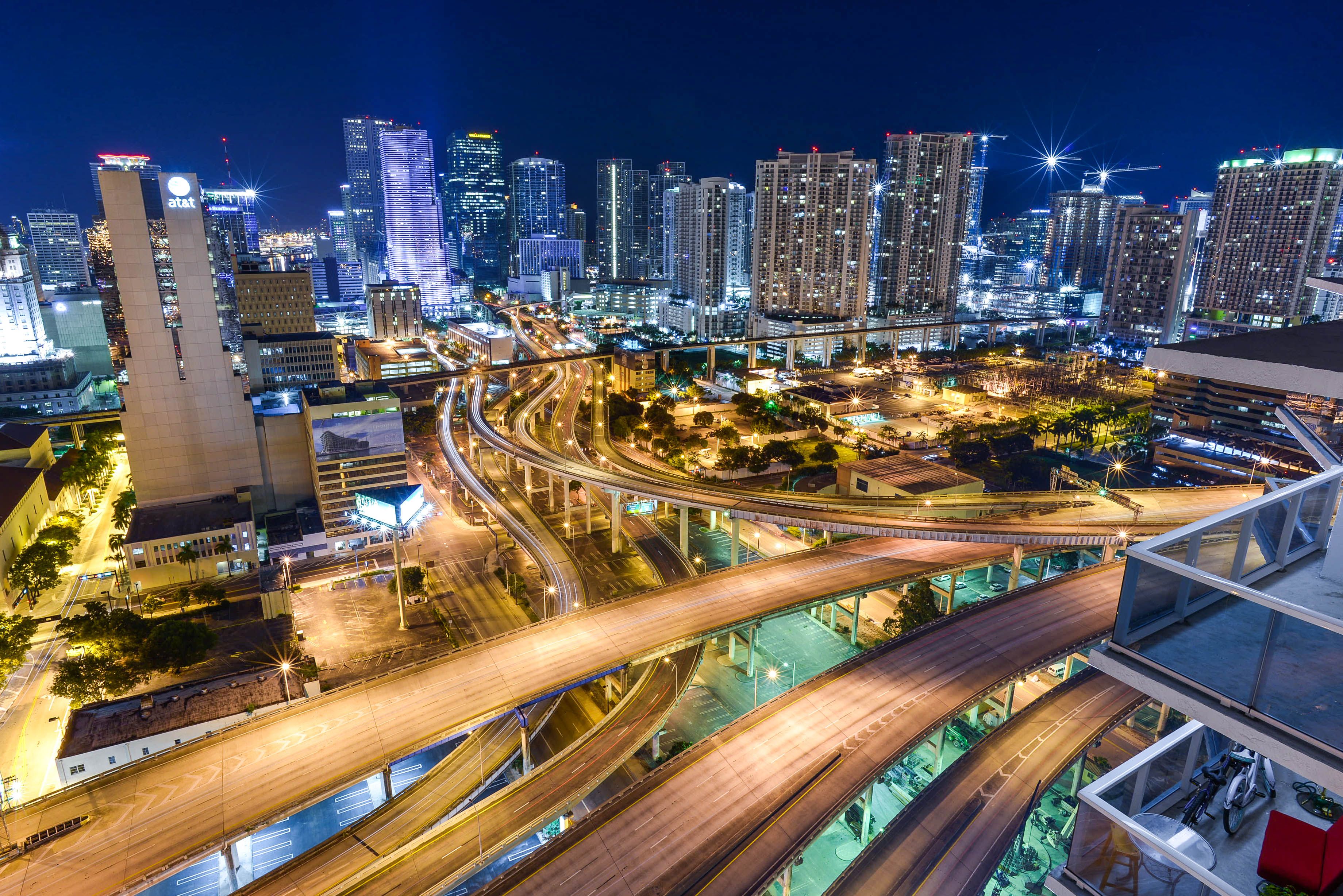 A night view of the city with the buildings lit up and the cars moving on the roads. - Miami