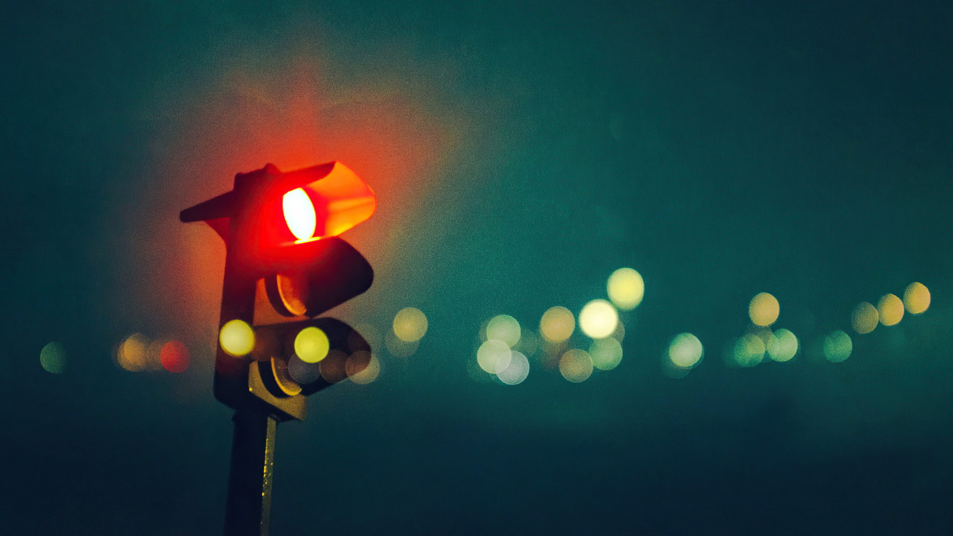 A traffic light with blurred lights in the background - Light red