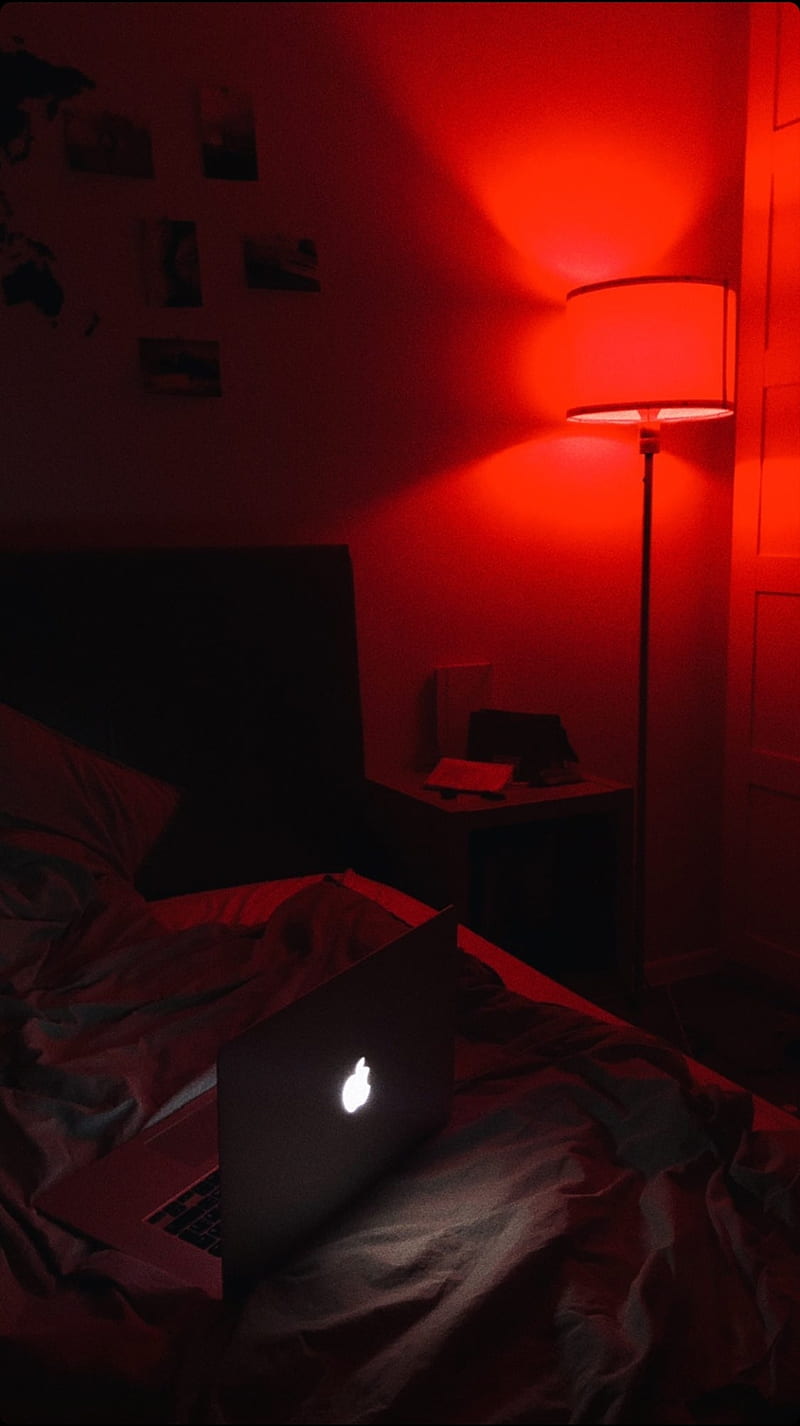 A laptop sitting on the bed in red light - Light red