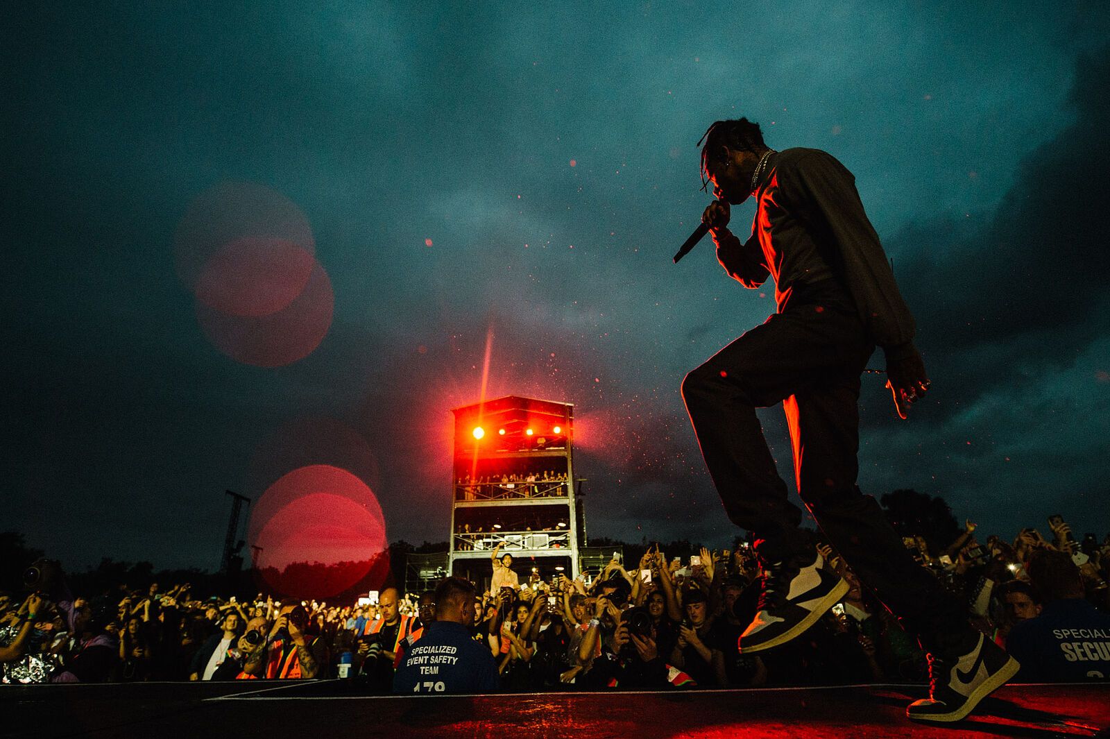 A man on stage performing for an audience - Travis Scott