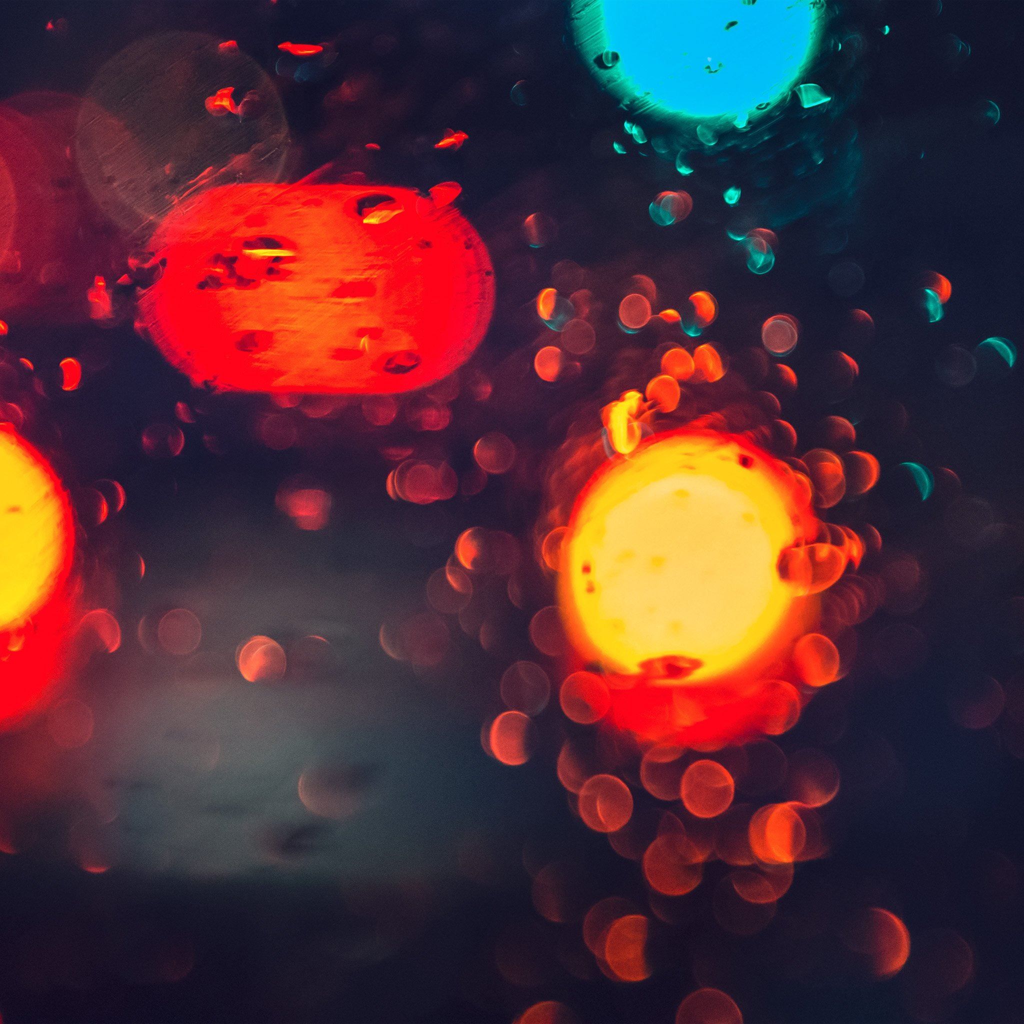 A photo of a rain-soaked window with blurred lights on the other side. - Dark orange