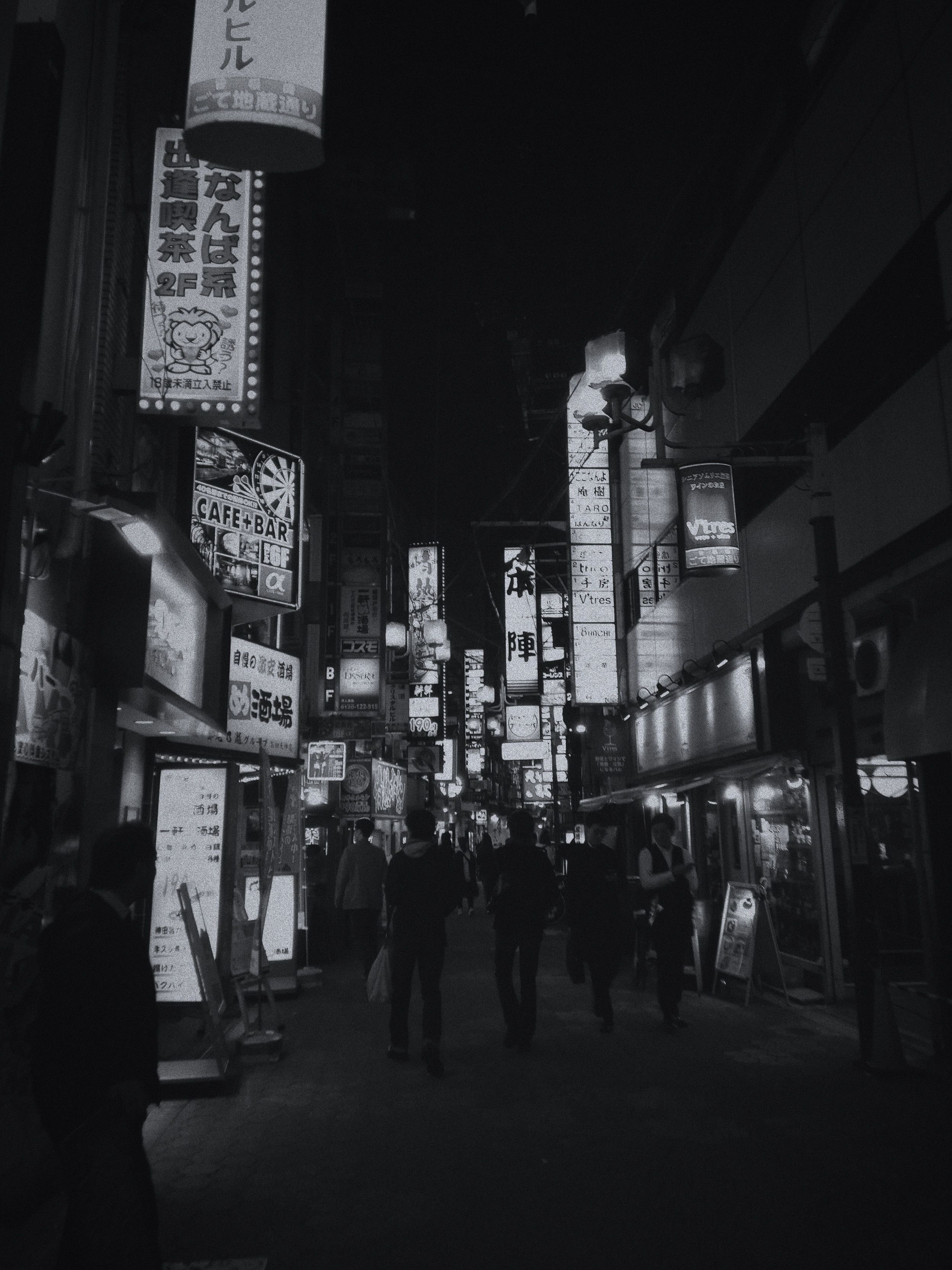 A black and white photo of a busy street at night. - Japanese