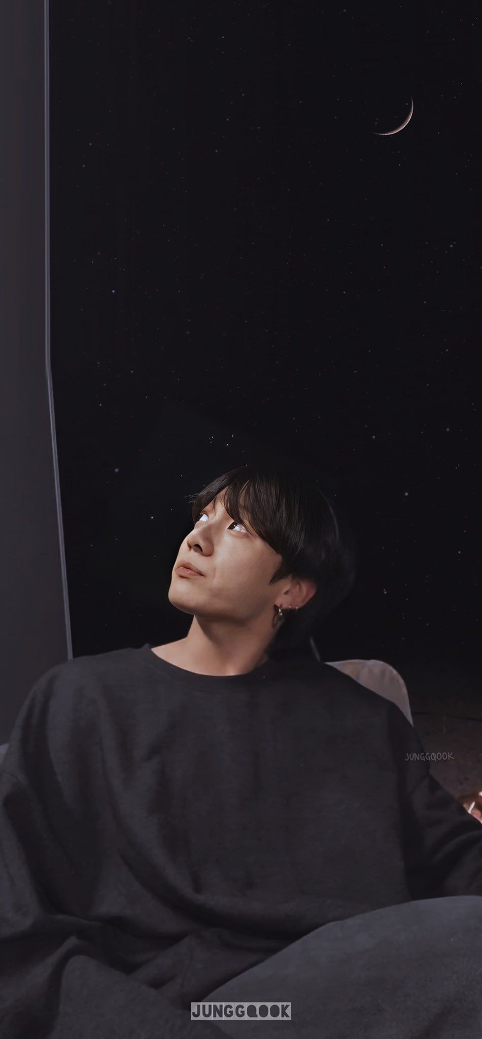 A man sitting on the couch looking at his phone - Jungkook