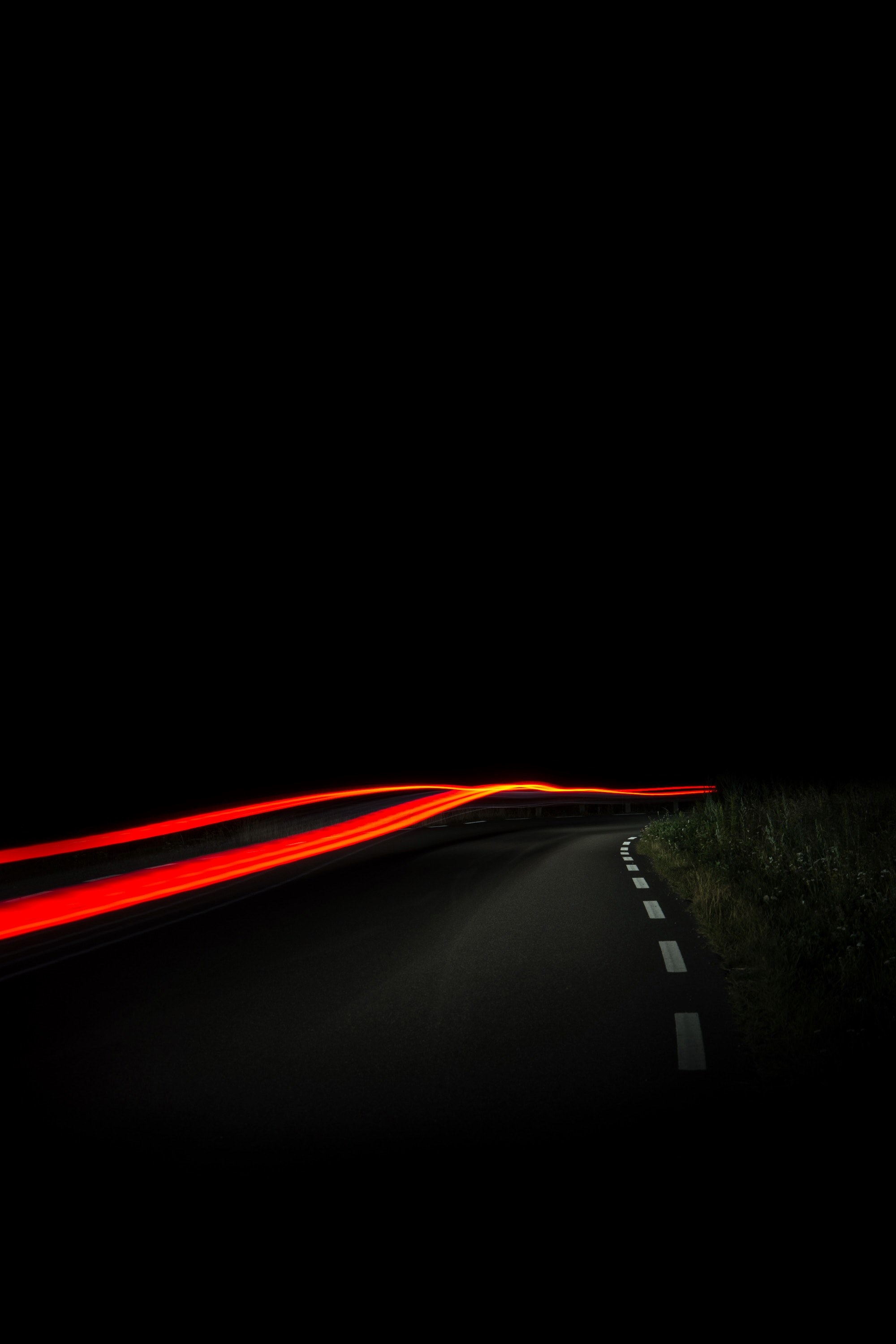 Wallpaper / a blurry night time shot of a road in sa with red car trails amidst the streets darkness, sa street light trail at night 4k wallpaper free download
