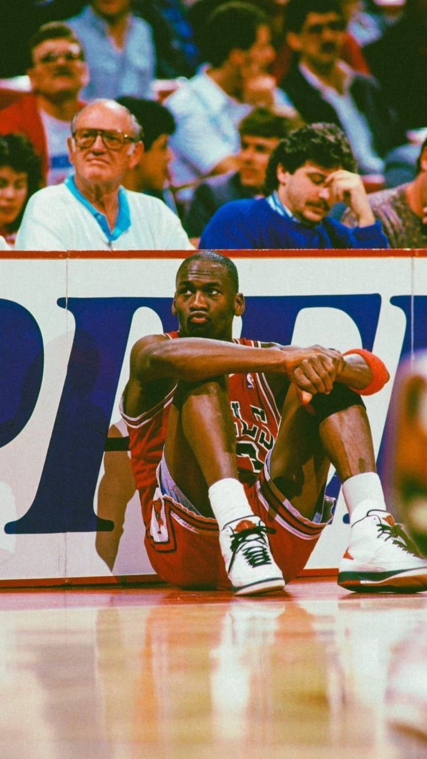 A basketball player sitting on the floor of an arena - NBA