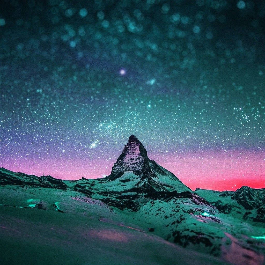 A starry night sky over a snow covered mountain - IPad