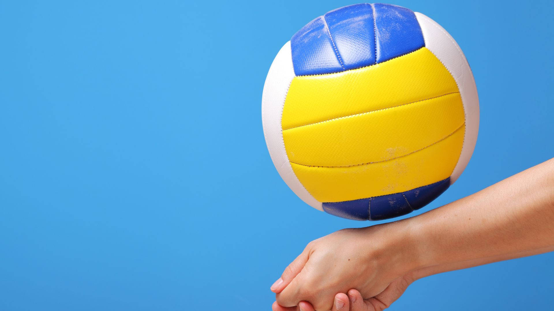 A person holding up an object with their hand - Volleyball