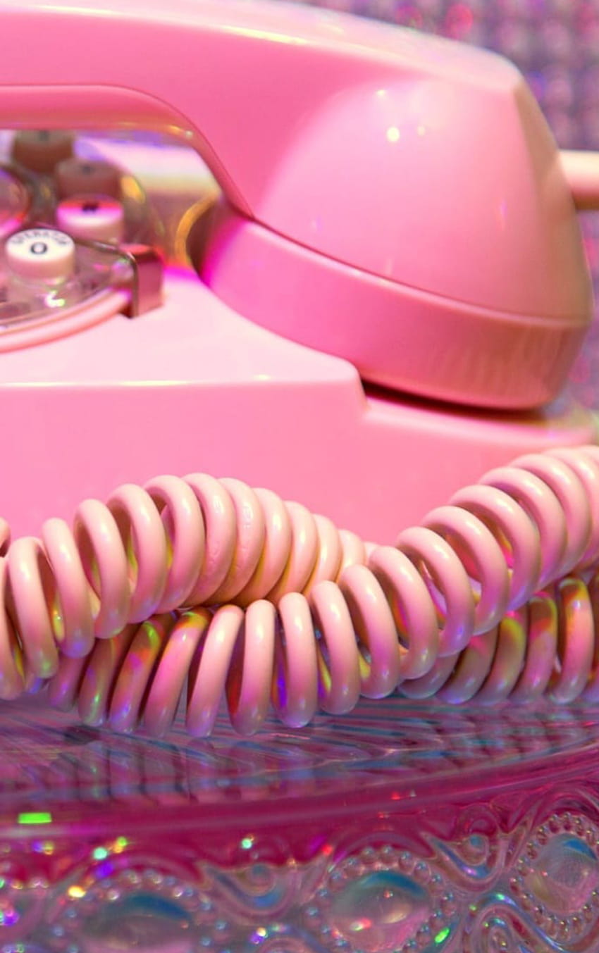 A pink rotary phone sits on a table. - Cute pink