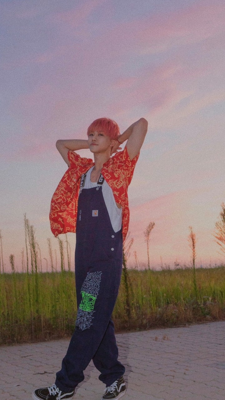 A person standing in front of a field - NCT
