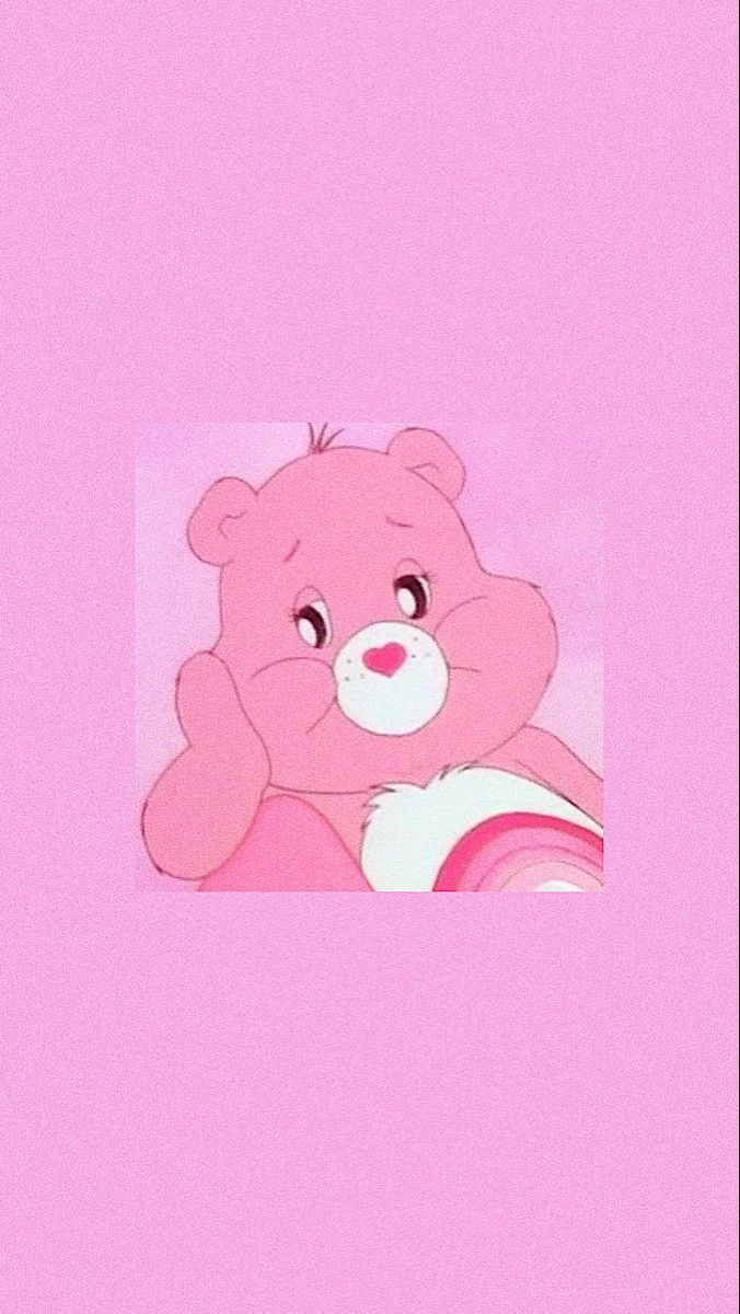 A pink care bear sitting on the ground - Teddy bear
