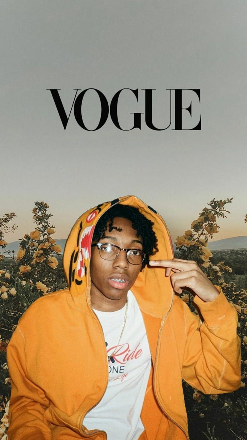A man wearing glasses and an orange hoodie - Vogue