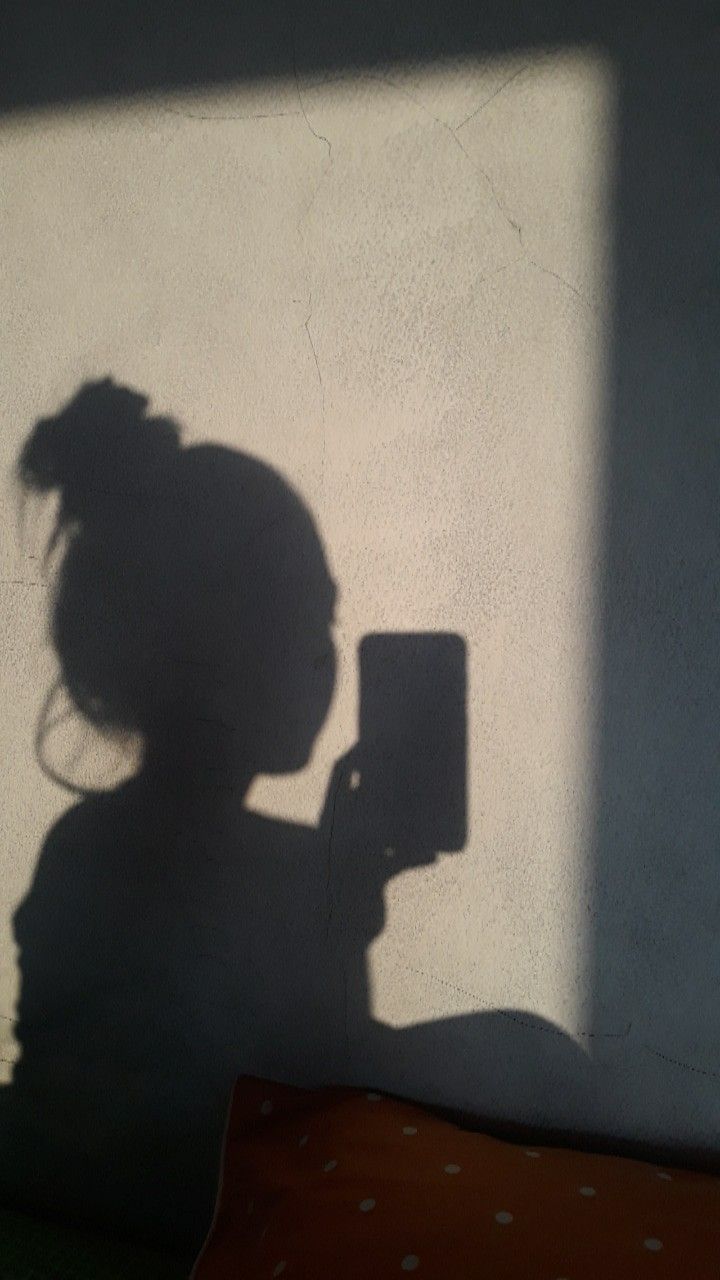Shadow of a woman holding a cell phone - Shadow