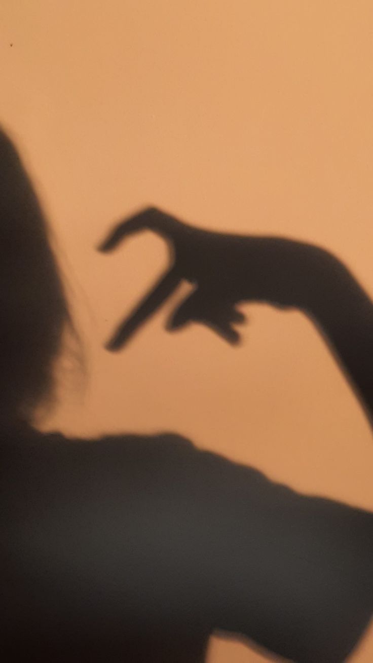 A shadow of someone holding up their hand - Shadow