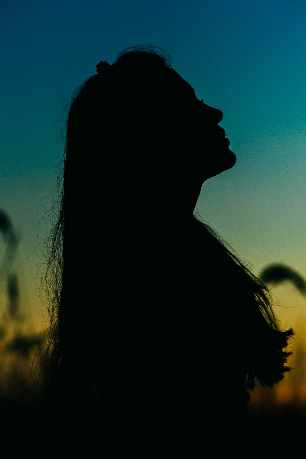 Silhouette of woman with long hair looking up at the sky - Shadow