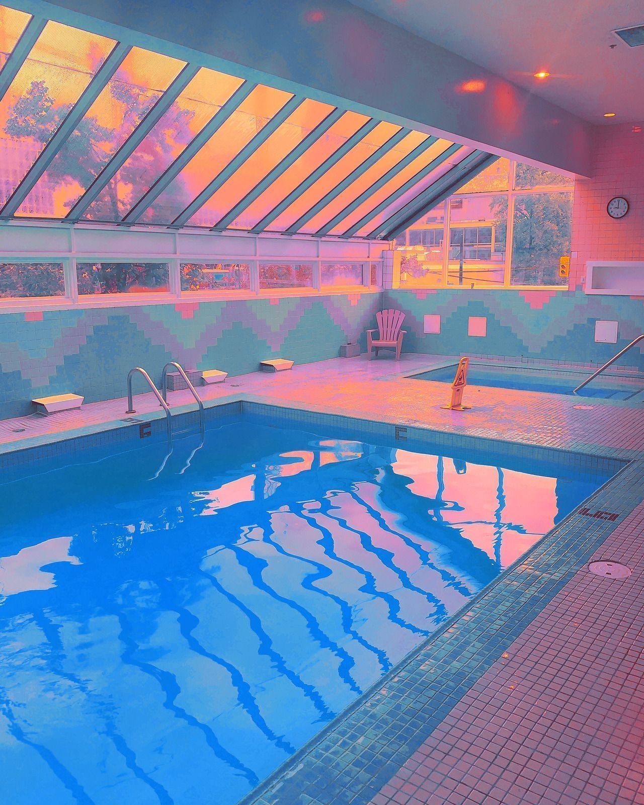 A pool with a skylight and a pink and blue aesthetic - Swimming pool