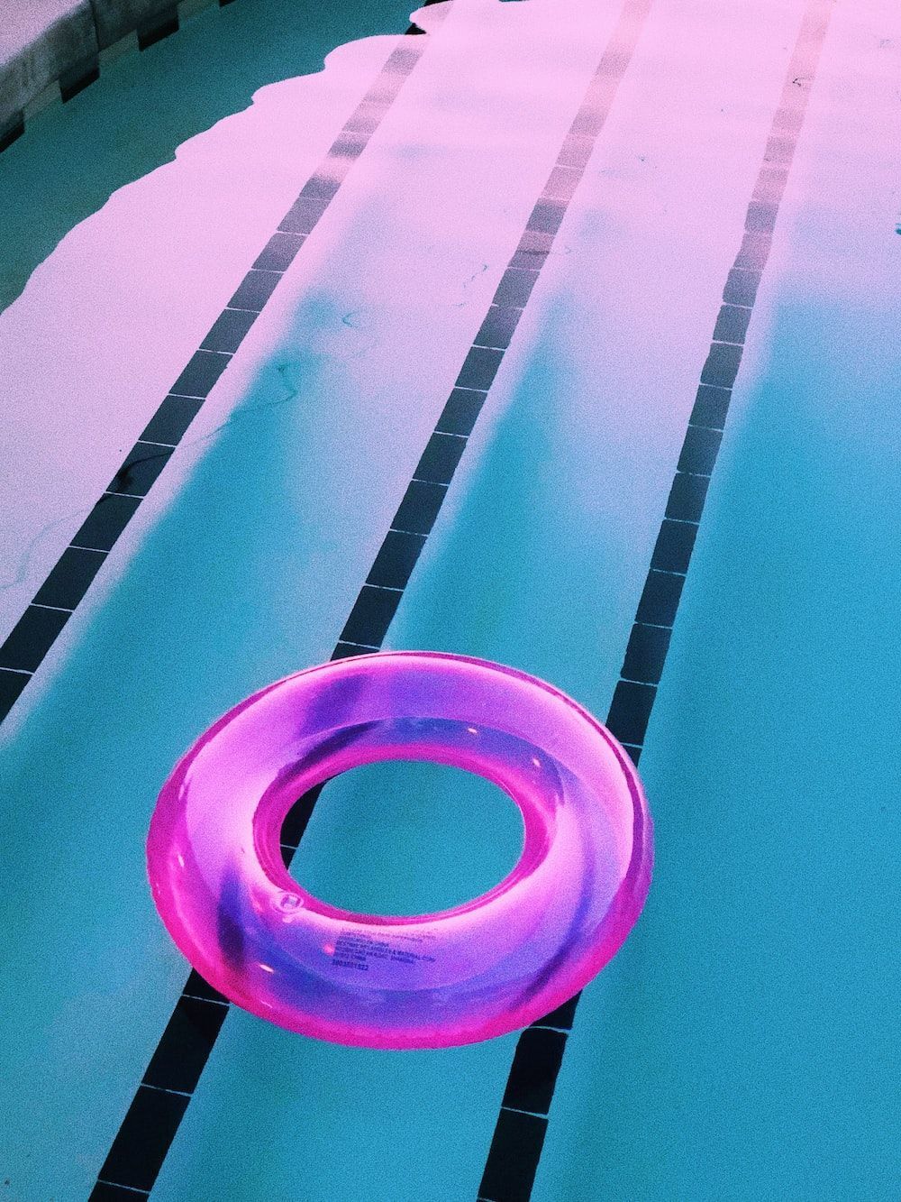 A pink inflatable ring floating on a pool - Swimming pool
