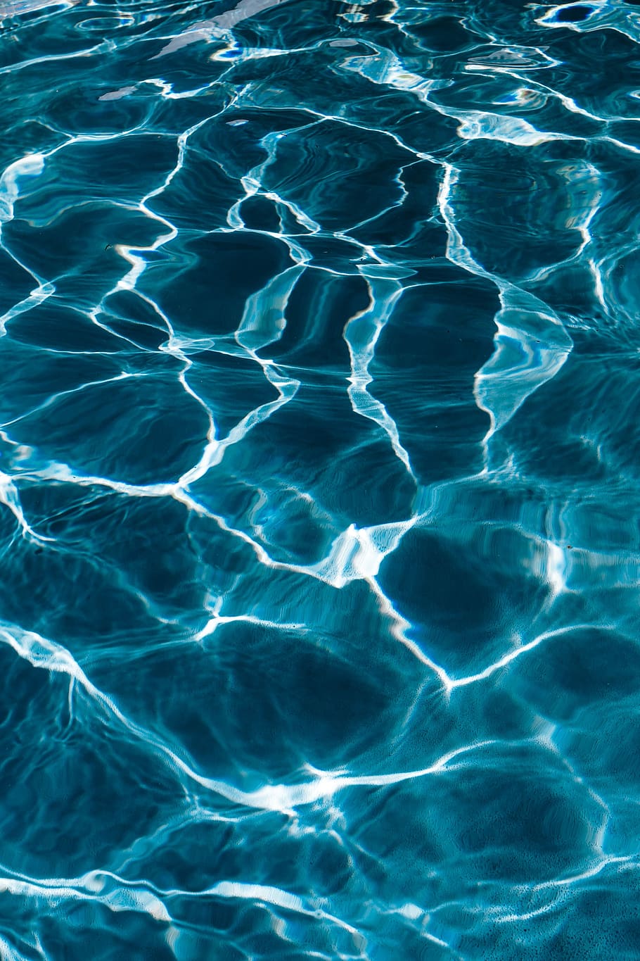 The surface of a pool with ripples and reflections - Swimming pool