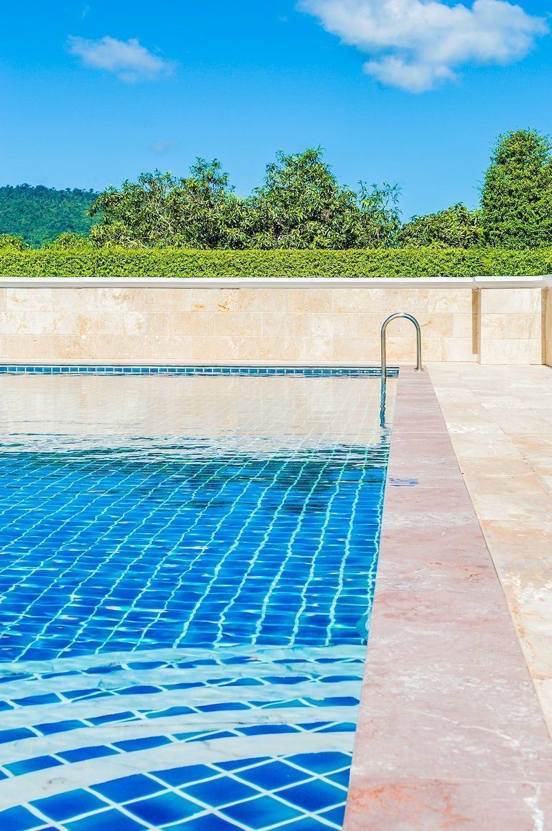 A pool with blue tiles and water - Swimming pool