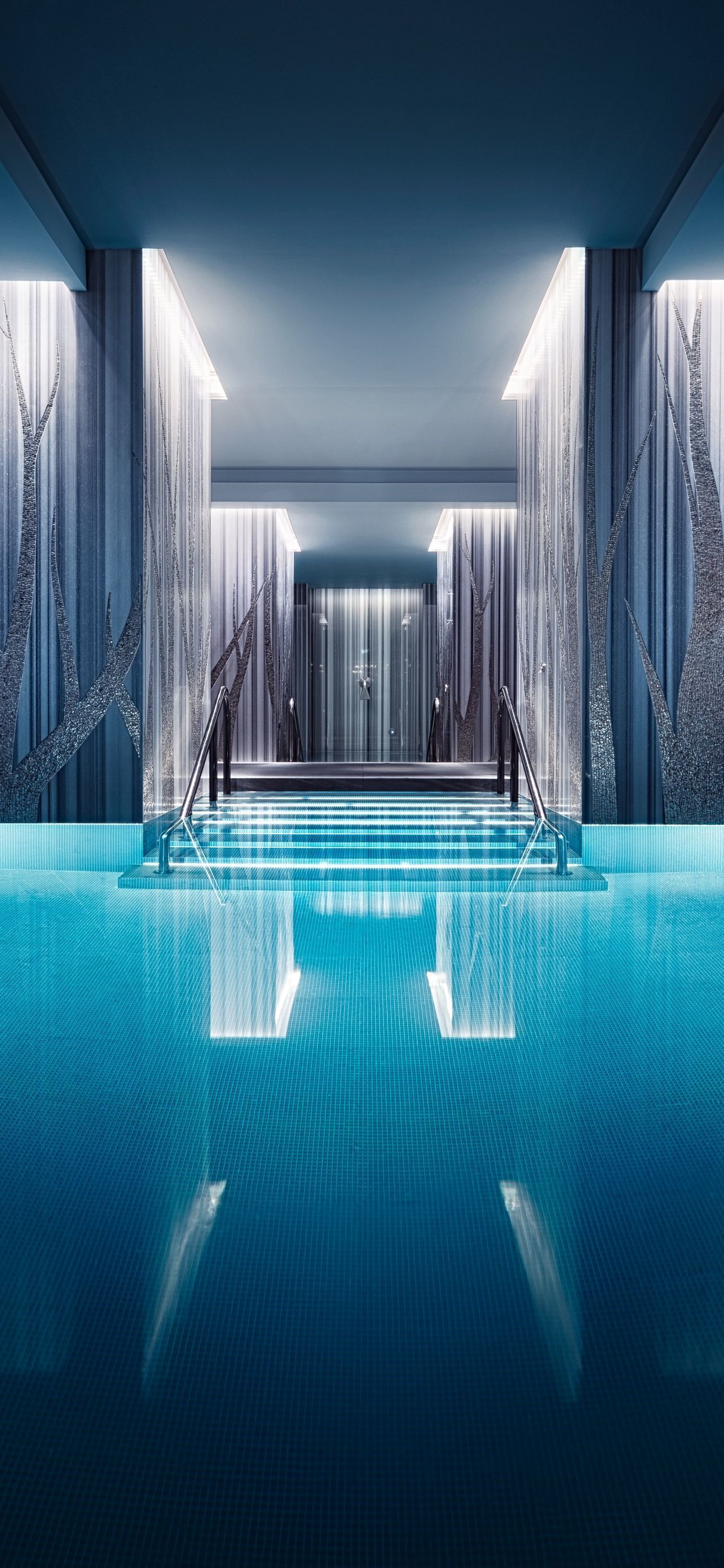 A large swimming pool with blue water and a light shining on it - Swimming pool