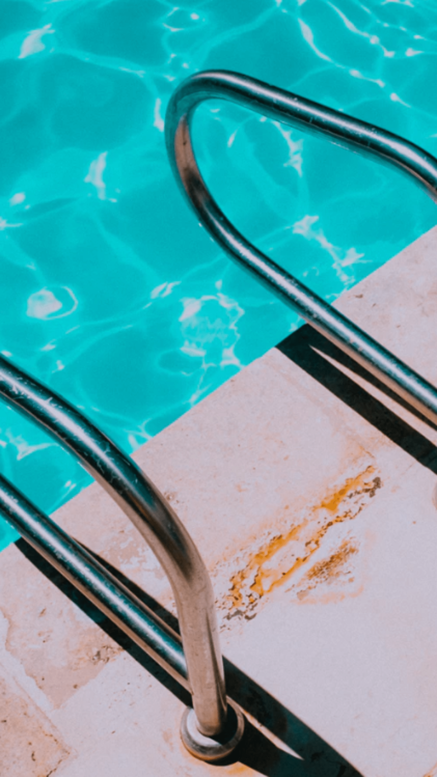 A metal ladder leading down to the water - Swimming pool