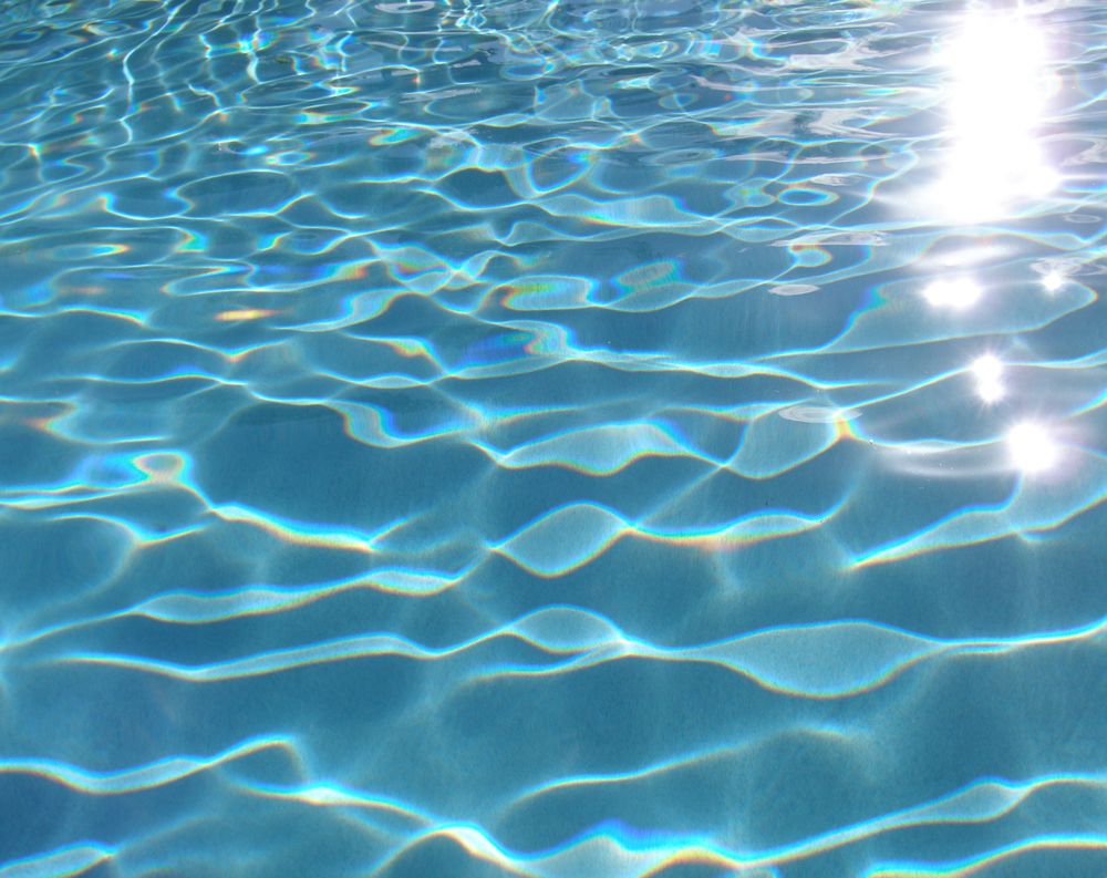 The sun reflects off the surface of a swimming pool. - Swimming pool