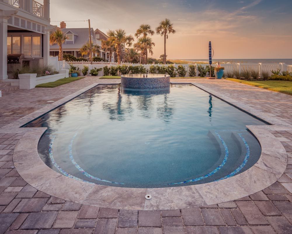 A pool with a brick patio around it - Swimming pool