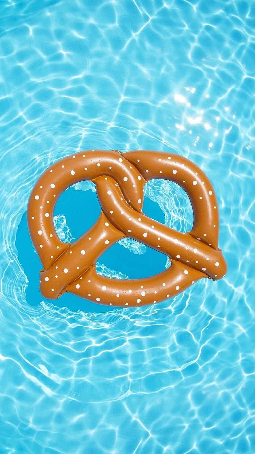 A giant inflatable pretzel floating in a pool - Swimming pool