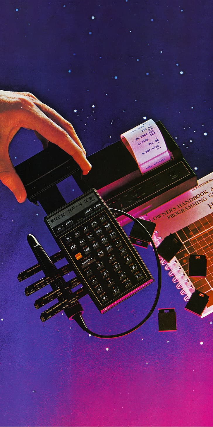 A hand holding a black calculator with a paper tape reader and keyboard - Technology