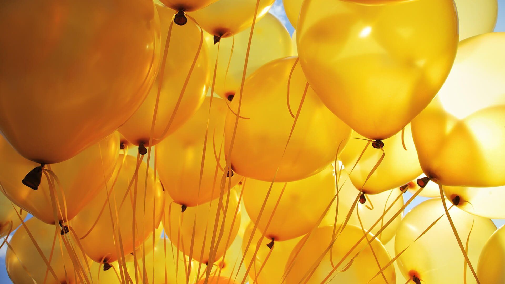 A bunch of yellow balloons are floating in the sky - Yellow