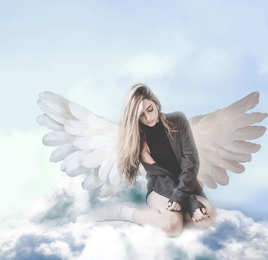 A girl with wings sitting on the clouds - Wings