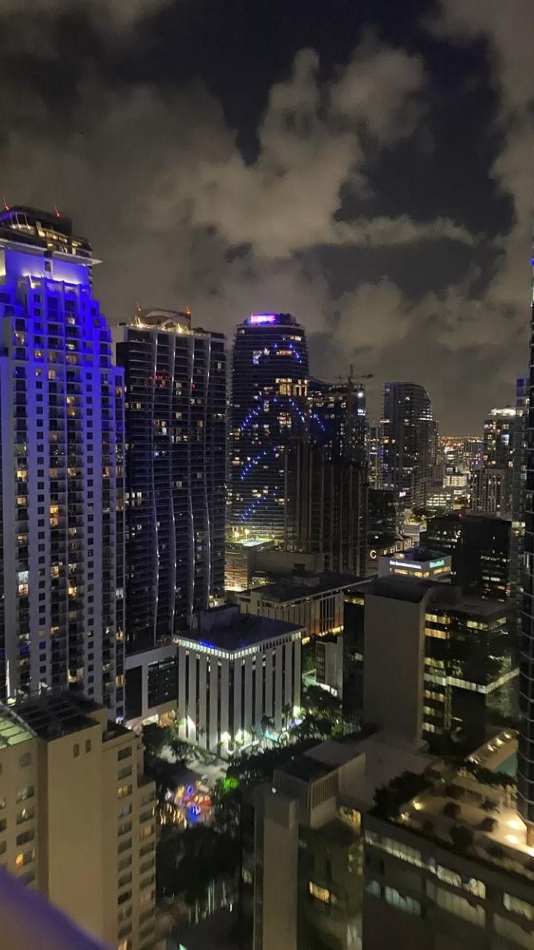 A city skyline at night with blue lights - Miami