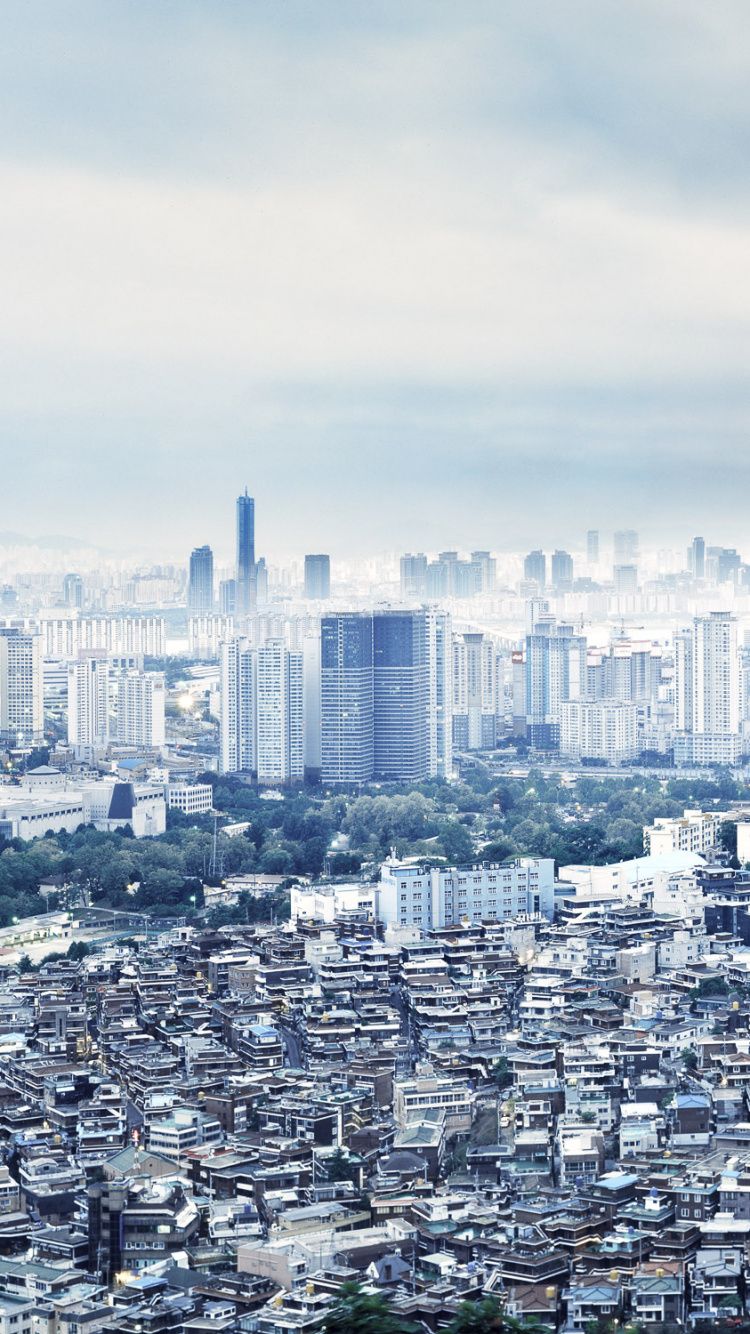 A cityscape with tall buildings and trees in the foreground - Seoul