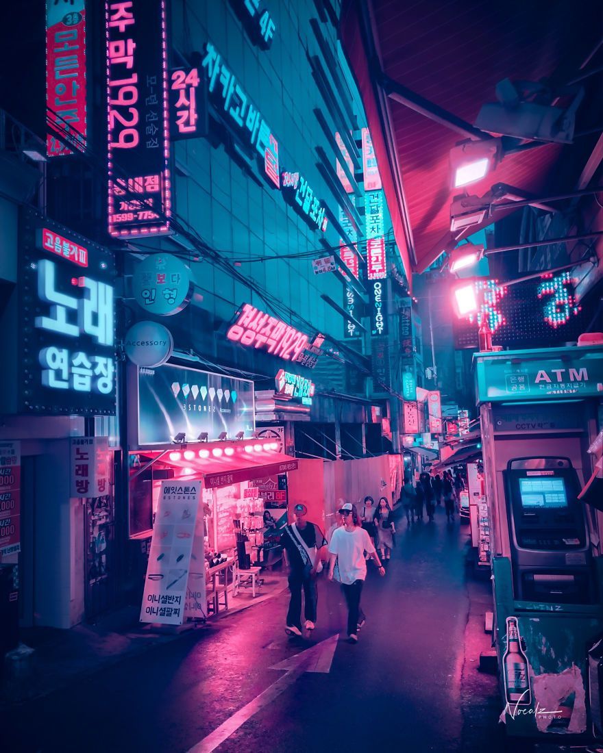 A street in Seoul at night with people walking around and neon signs - Seoul