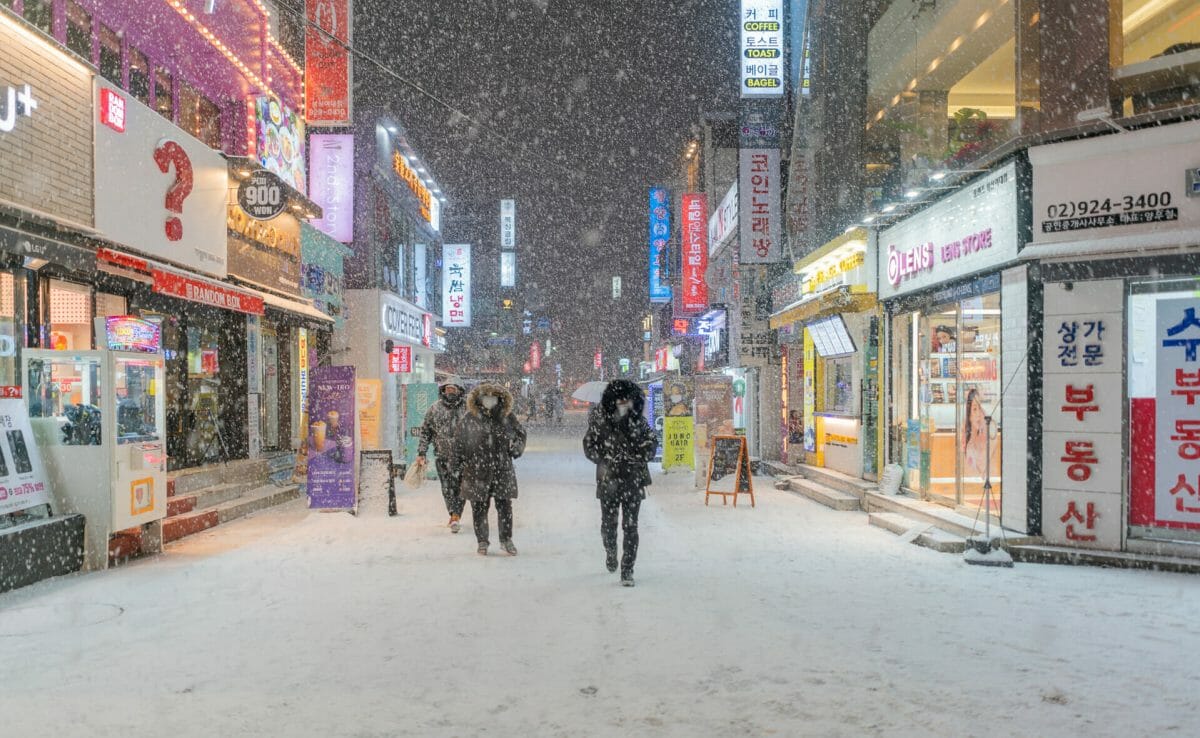 A group of people walking down the street in snow - Seoul
