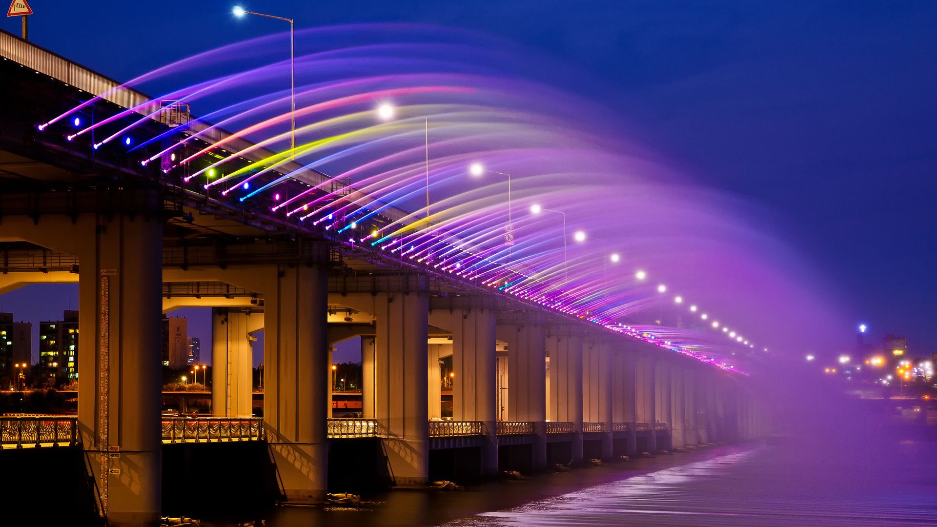A bridge with lights and water flowing under it - Seoul